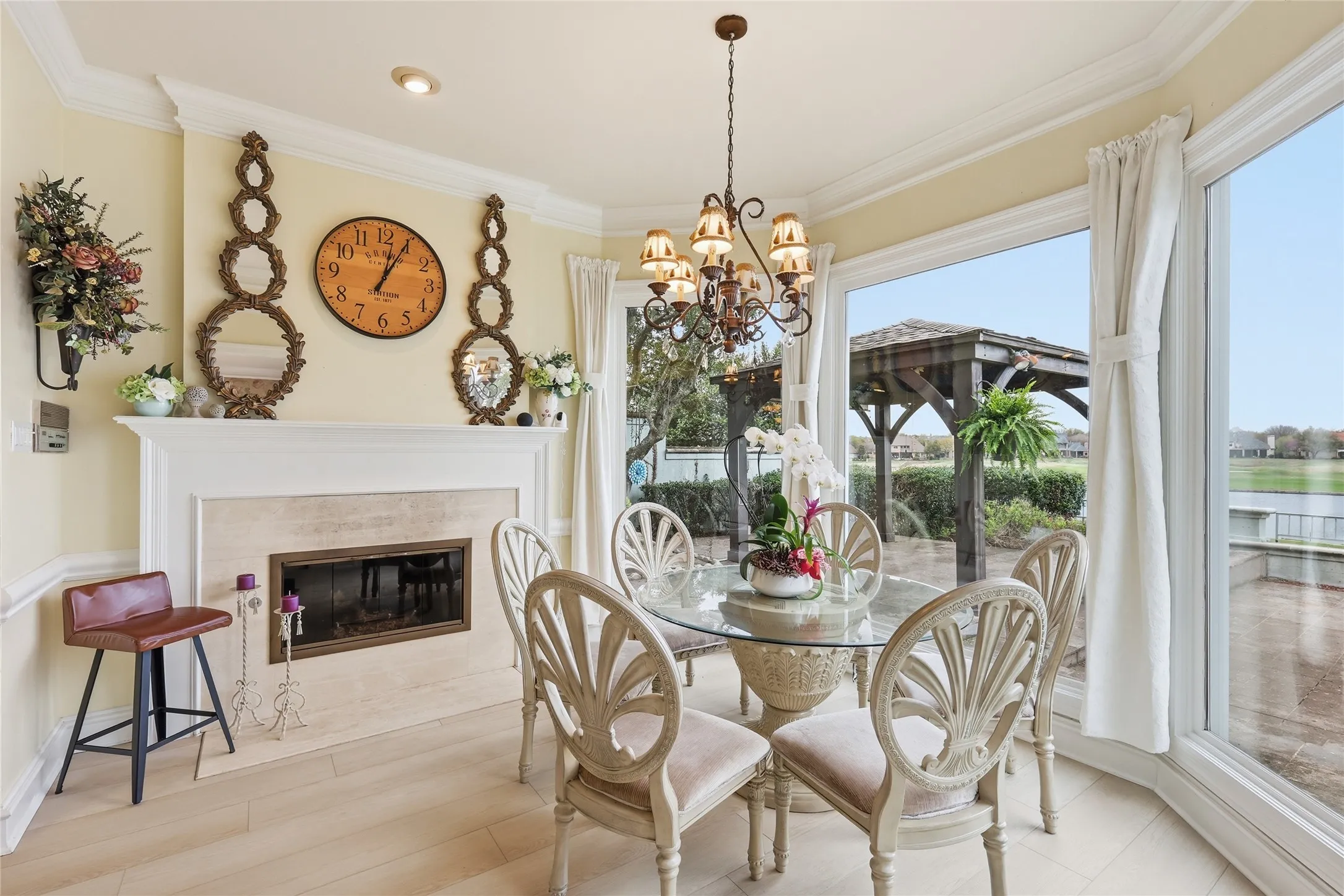 Dining space featuring ornamental molding, hanging lights, light wood-type flooring, and a premium fireplace