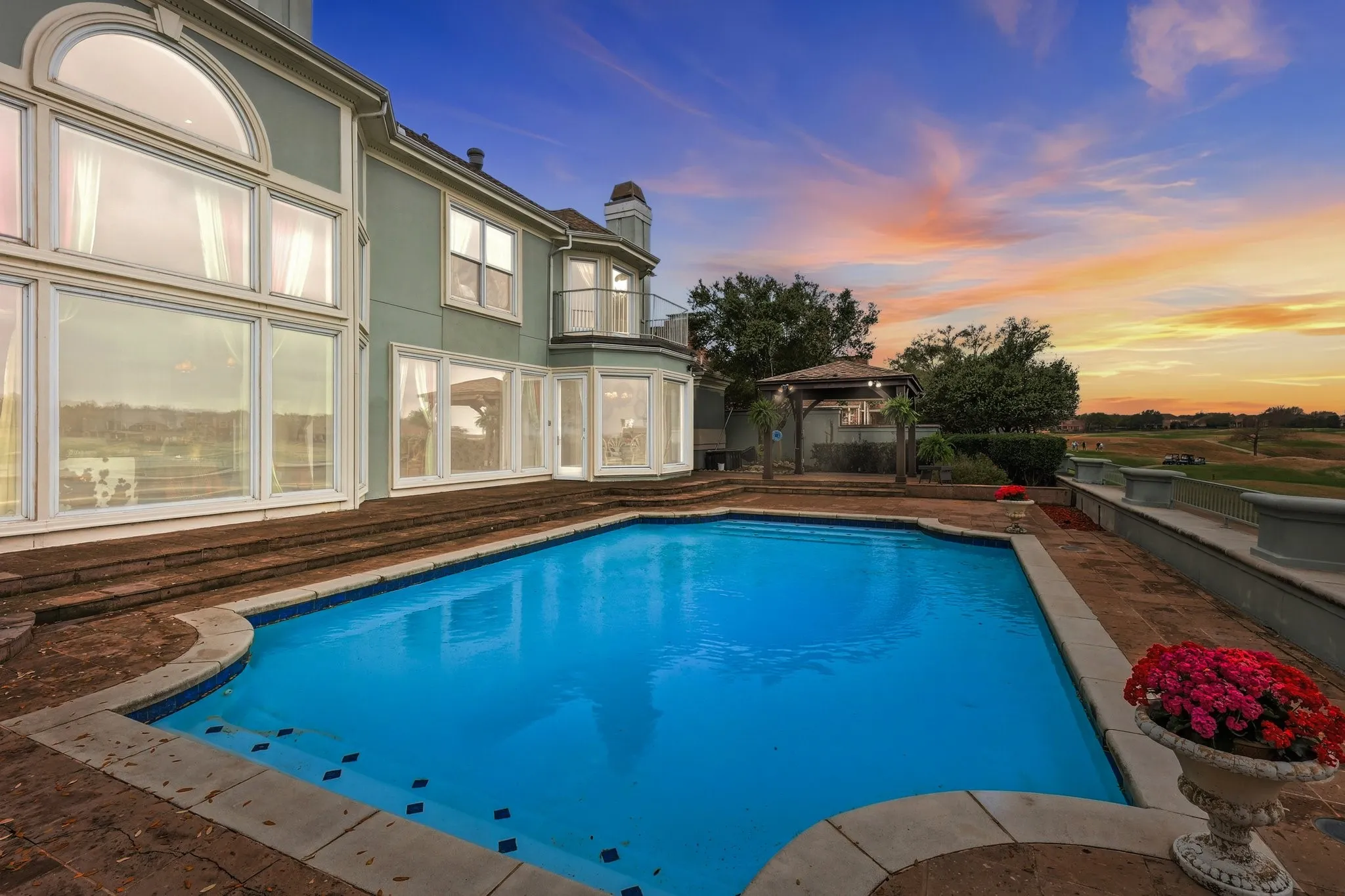 Pool at dusk featuring a gazebo, an outdoor pool, a patio, and a fenced backyard