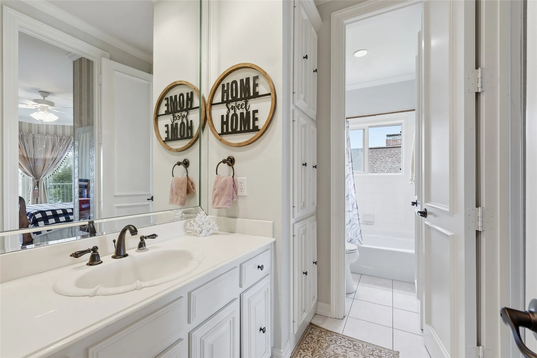 Bathroom with ornamental molding, vanity, light tile patterned flooring, a ceiling fan, and shower / bath combo