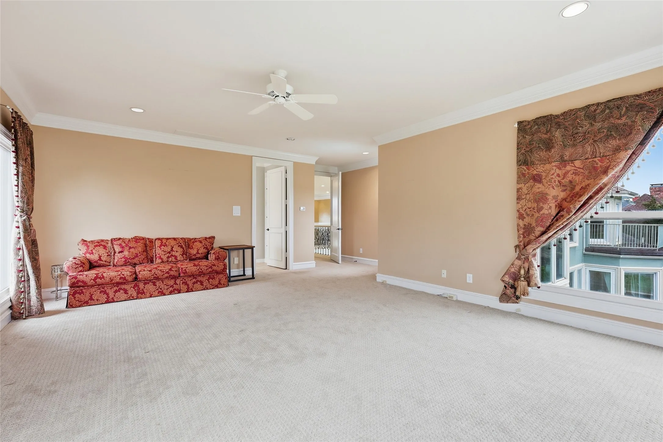 Unfurnished living room with ceiling fan, ornamental molding, recessed lighting, and light colored carpet