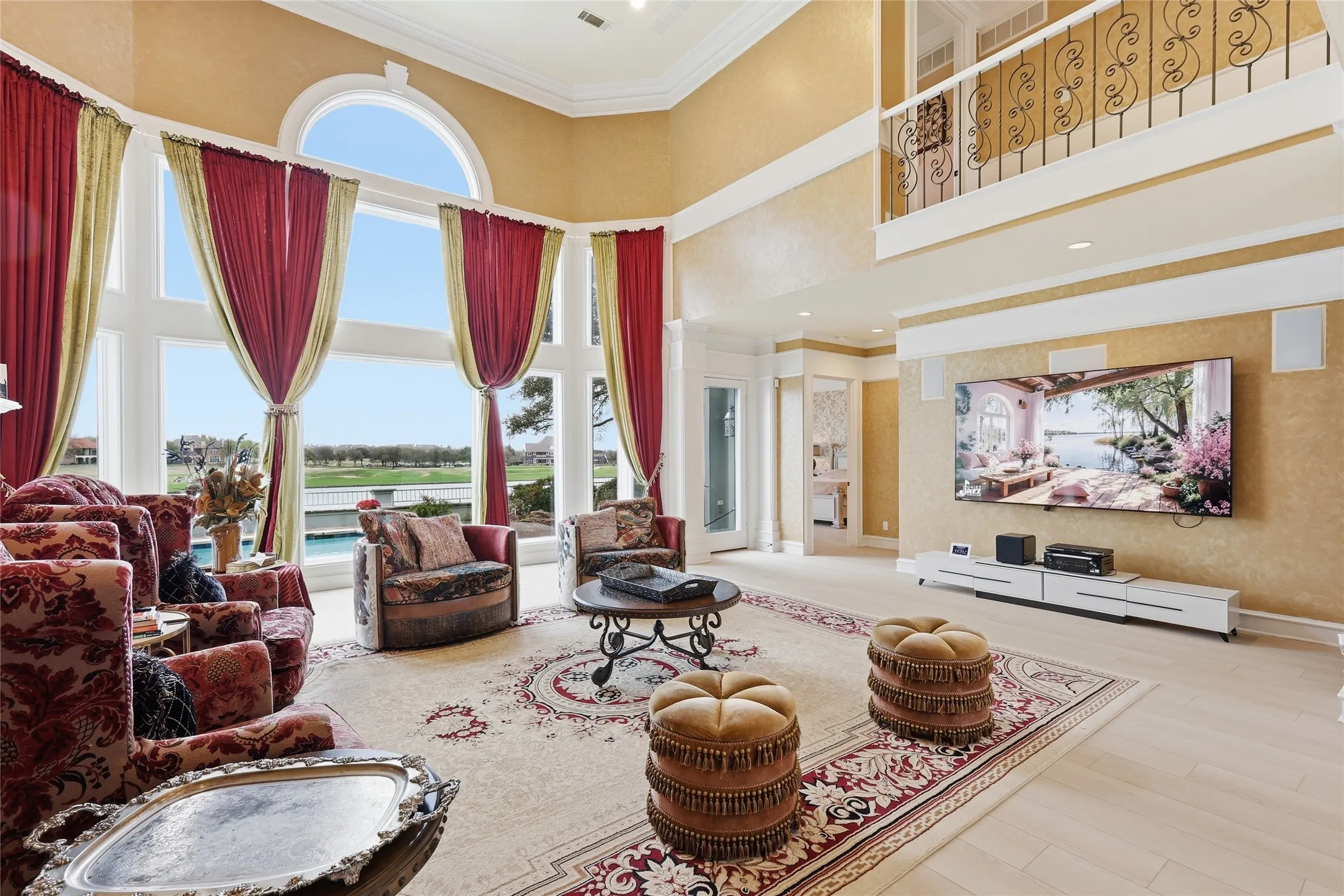 Living area featuring ornamental molding, light wood finished floors, and a high ceiling