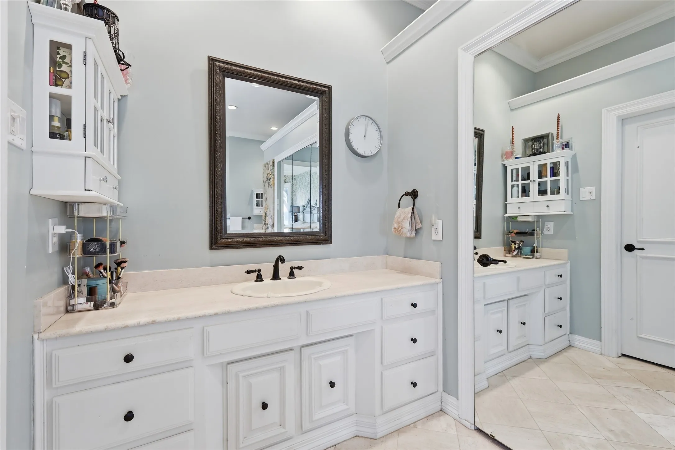 Bathroom with crown molding, vanity, and light tile patterned flooring