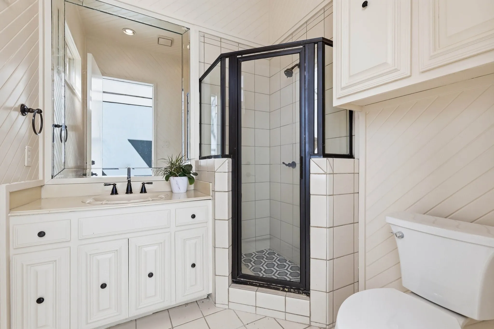 Full bathroom featuring vanity, a stall shower, and light tile patterned floors