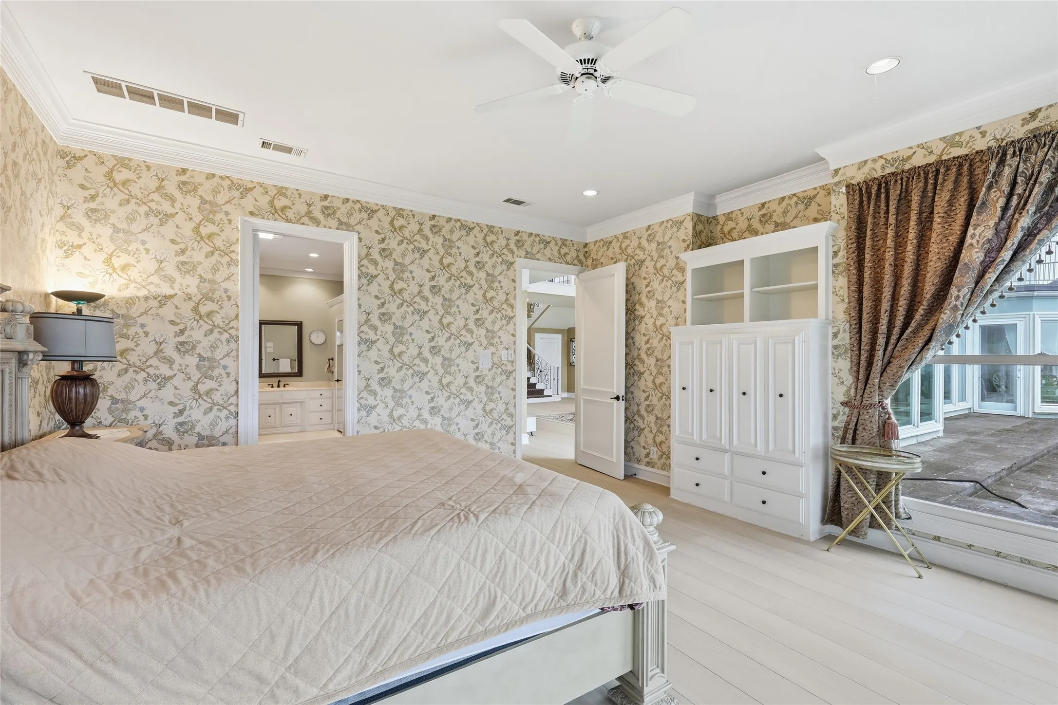 Bedroom with light wood-style flooring, ornamental molding, a ceiling fan, connected bathroom, and recessed lighting
