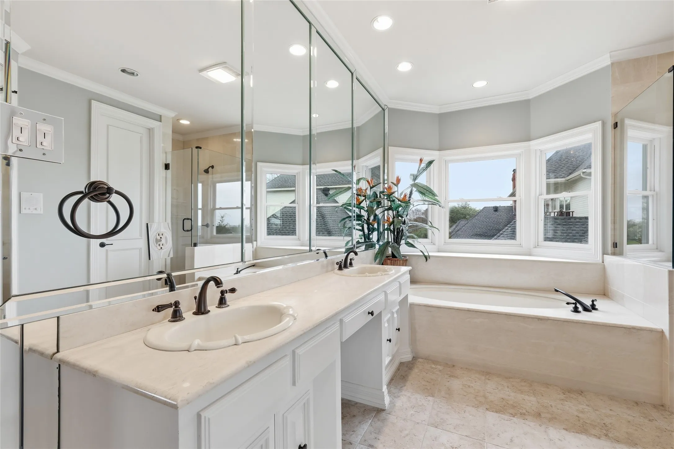 Full bathroom with double vanity, a garden tub, a stall shower, and ornamental molding
