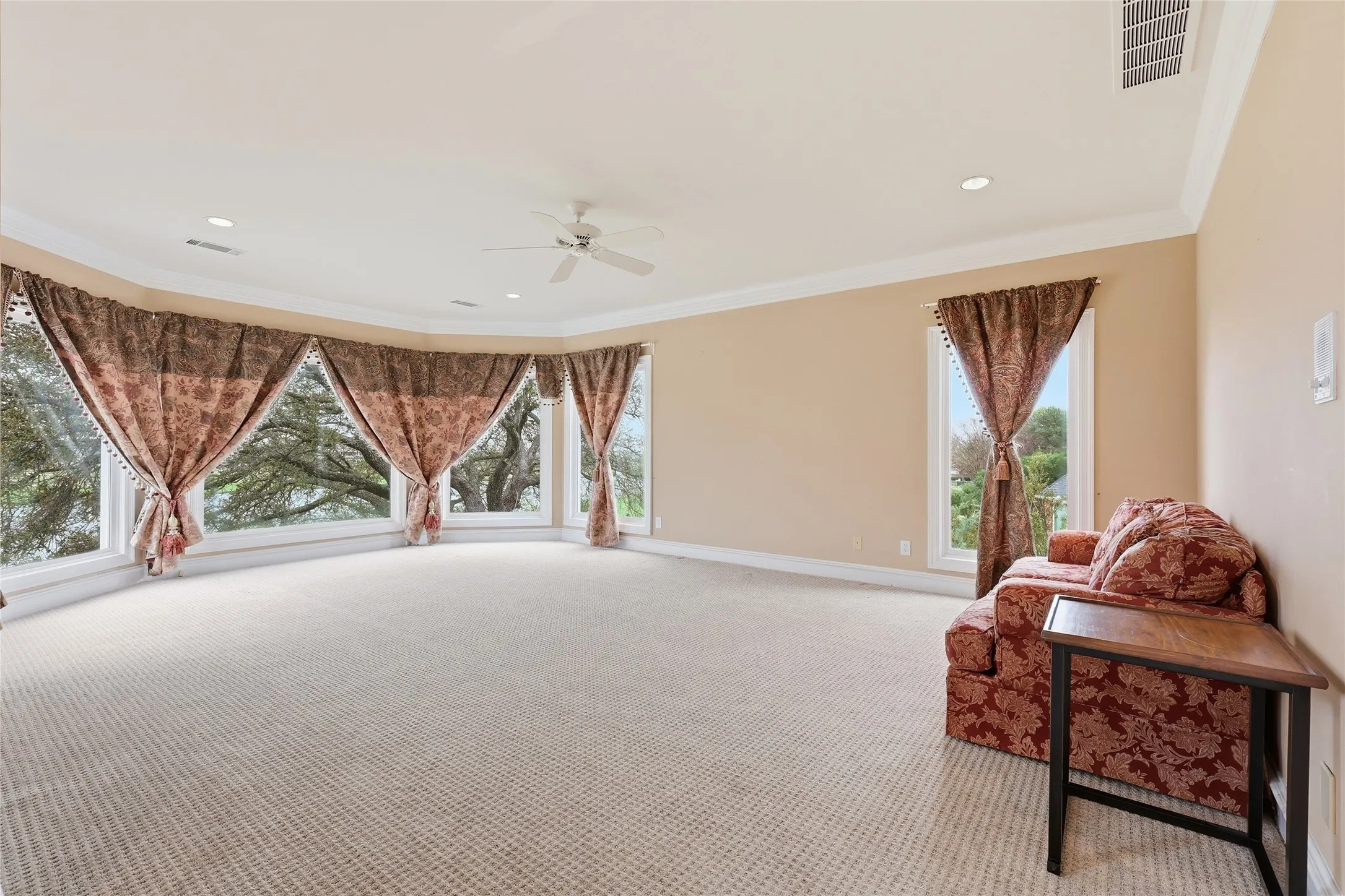 Sitting room with a ceiling fan, crown molding, light carpet, and recessed lighting