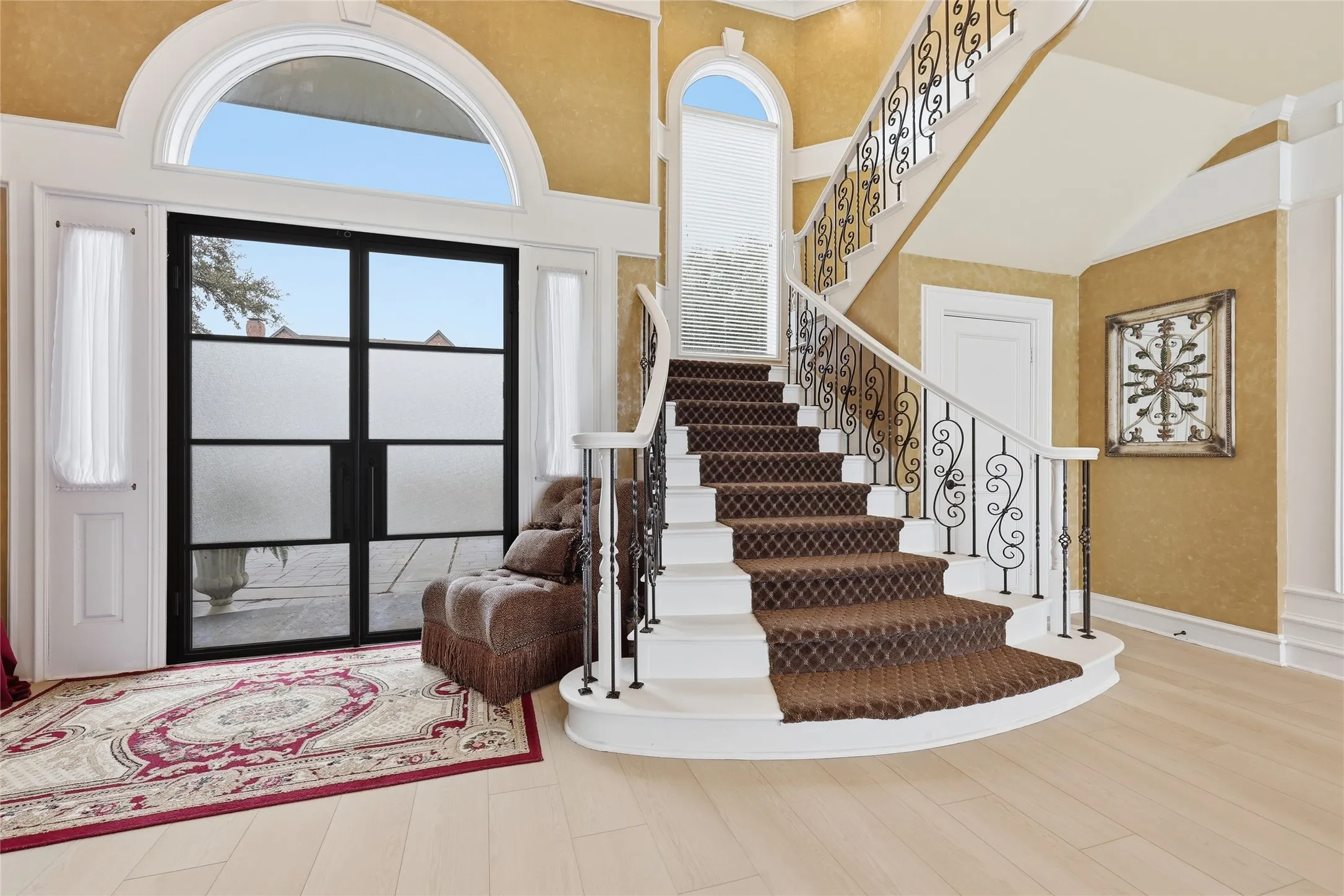Foyer featuring light wood-style floors and a high ceiling