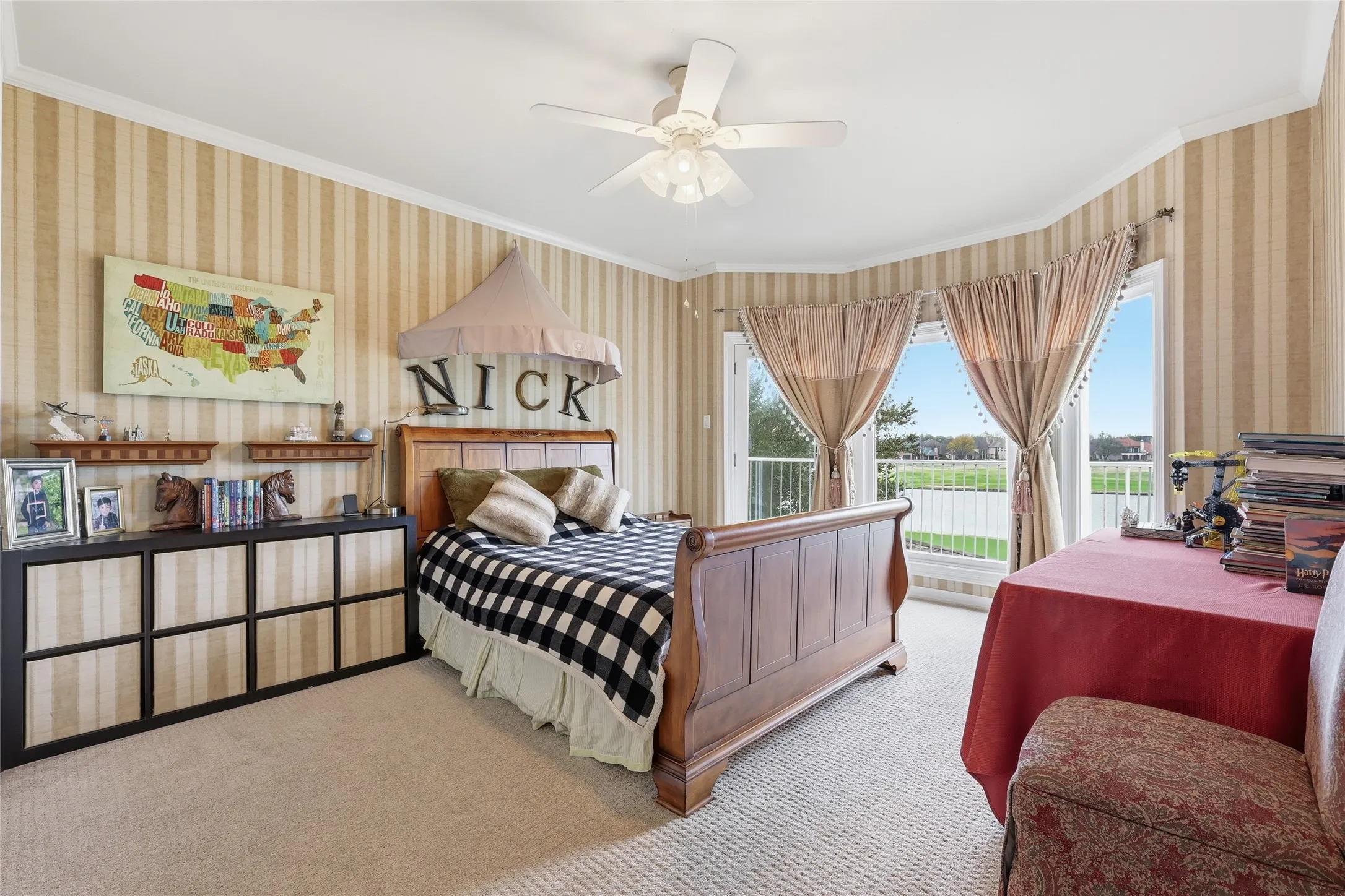 Bedroom featuring wallpapered walls, ornamental molding, light carpet, access to exterior, and ceiling fan
