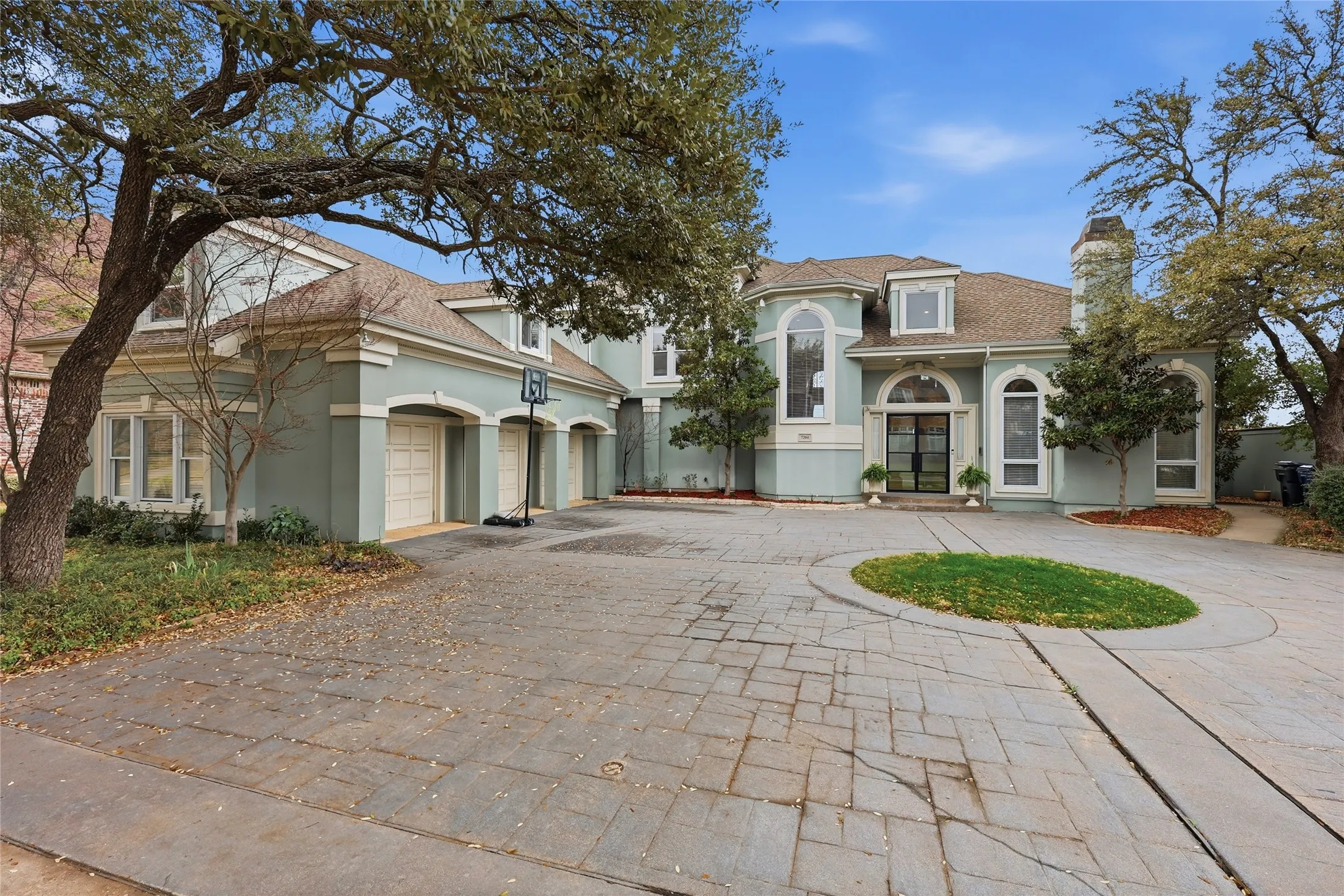 Mediterranean / spanish house with curved driveway, stucco siding, a chimney, and french doors