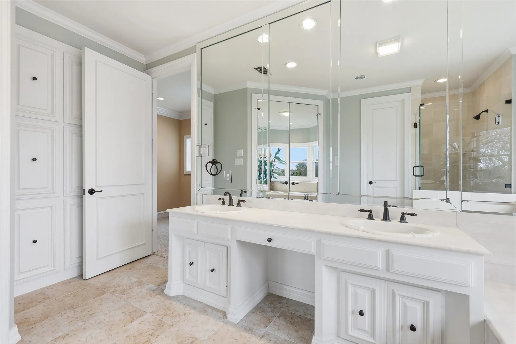 Bathroom with double vanity, a stall shower, and crown molding