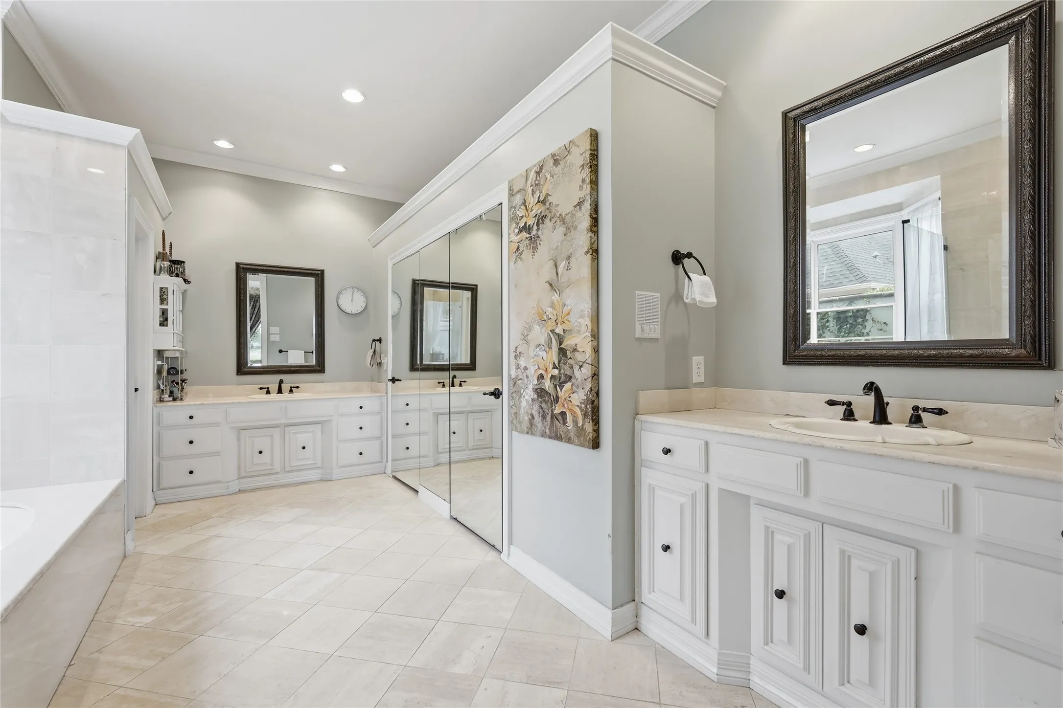 Full bath with two vanities, ornamental molding, recessed lighting, and a tub to relax in