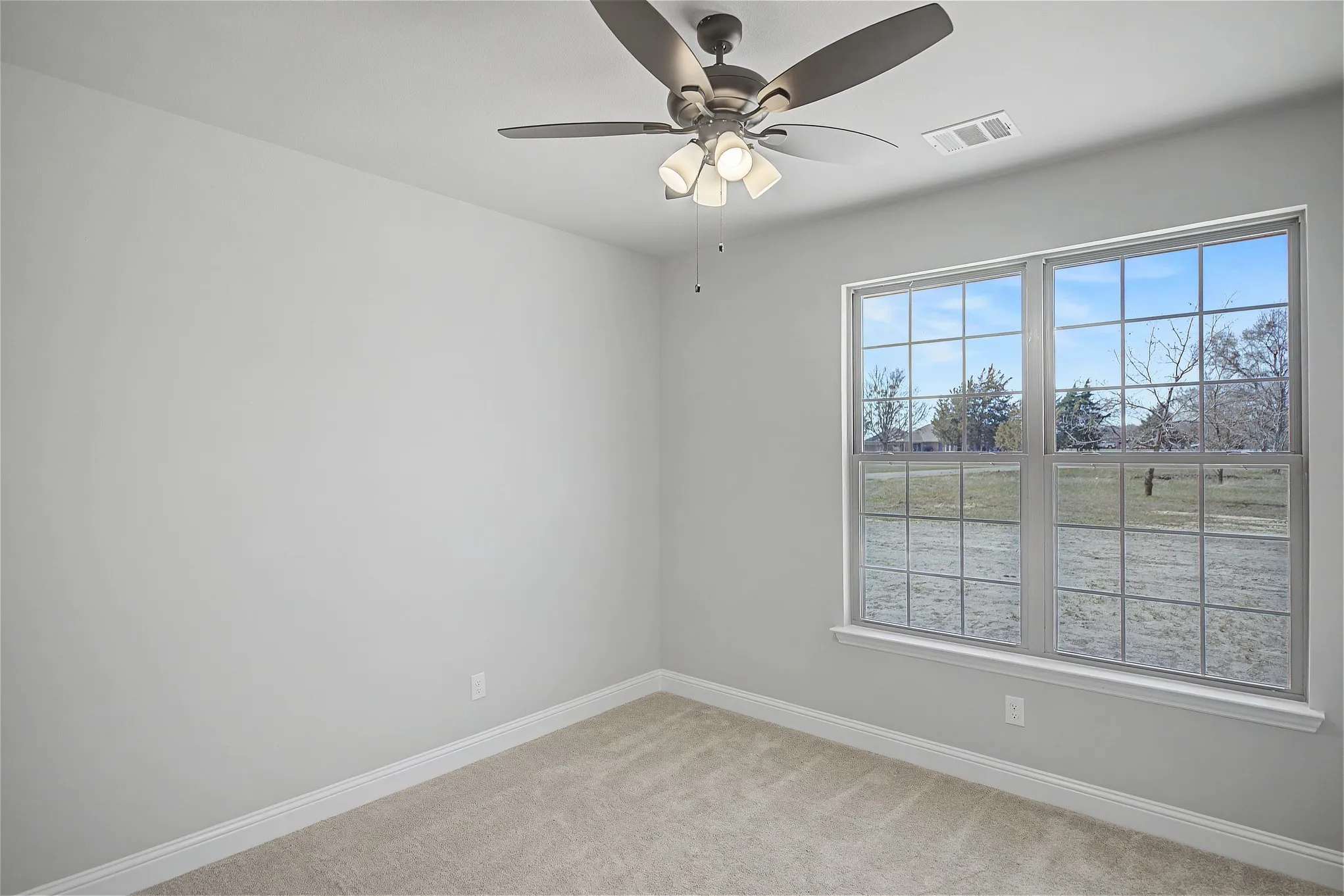 Unfurnished room featuring light colored carpet and ceiling fan
