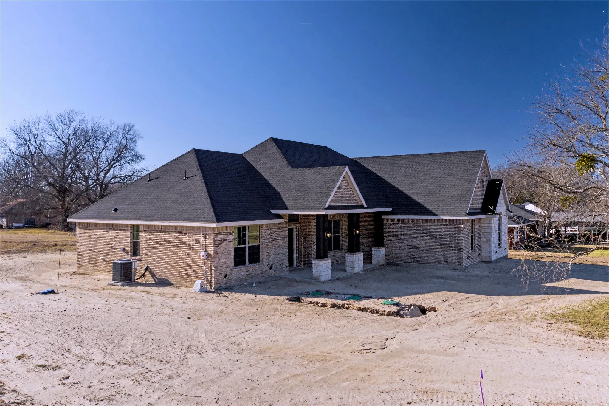 Back of house with brick siding and a shingled roof