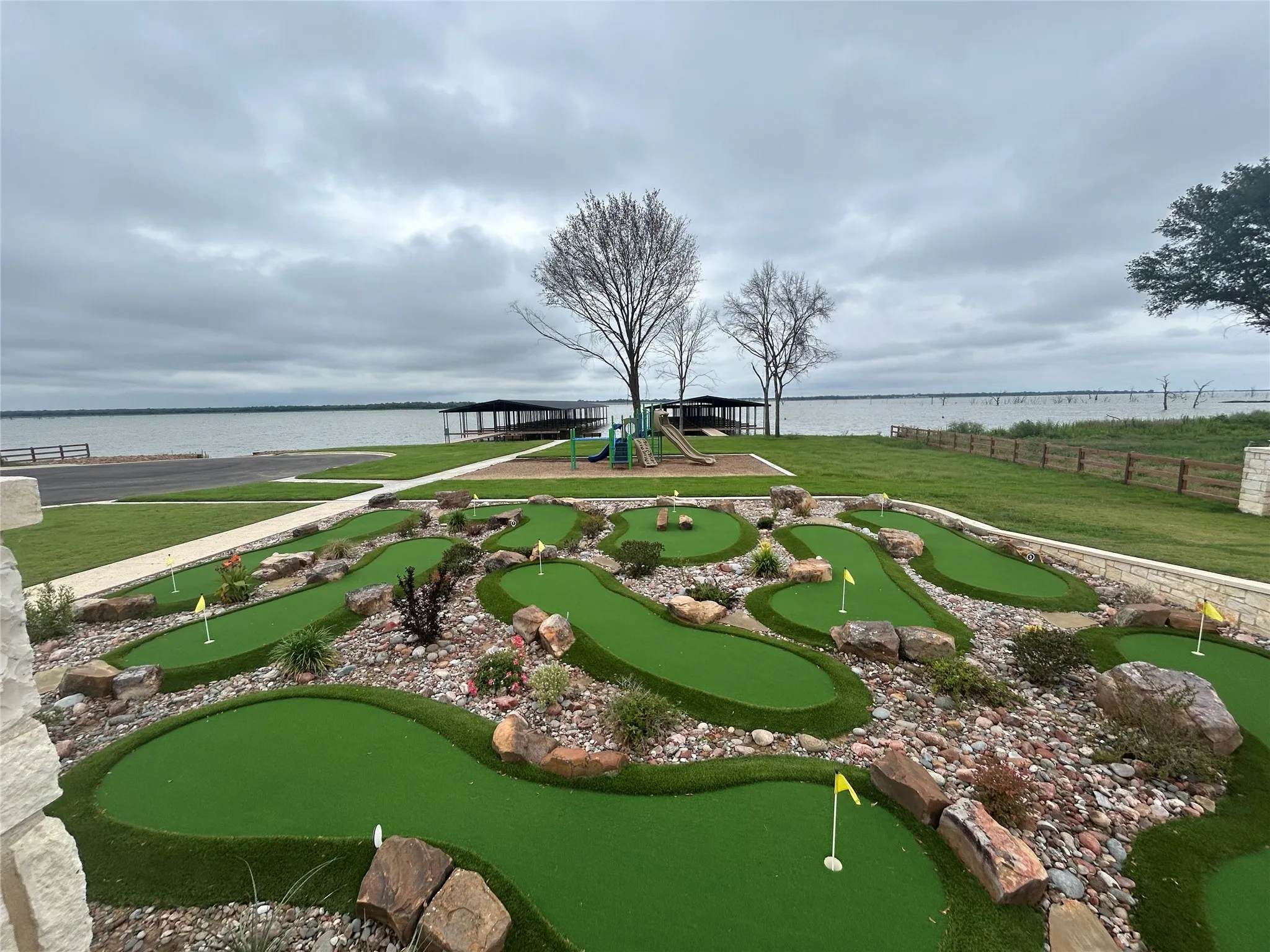 Miniature golf course featuring multiple holes with artificial turf, surrounded by decorative rocks and plantings