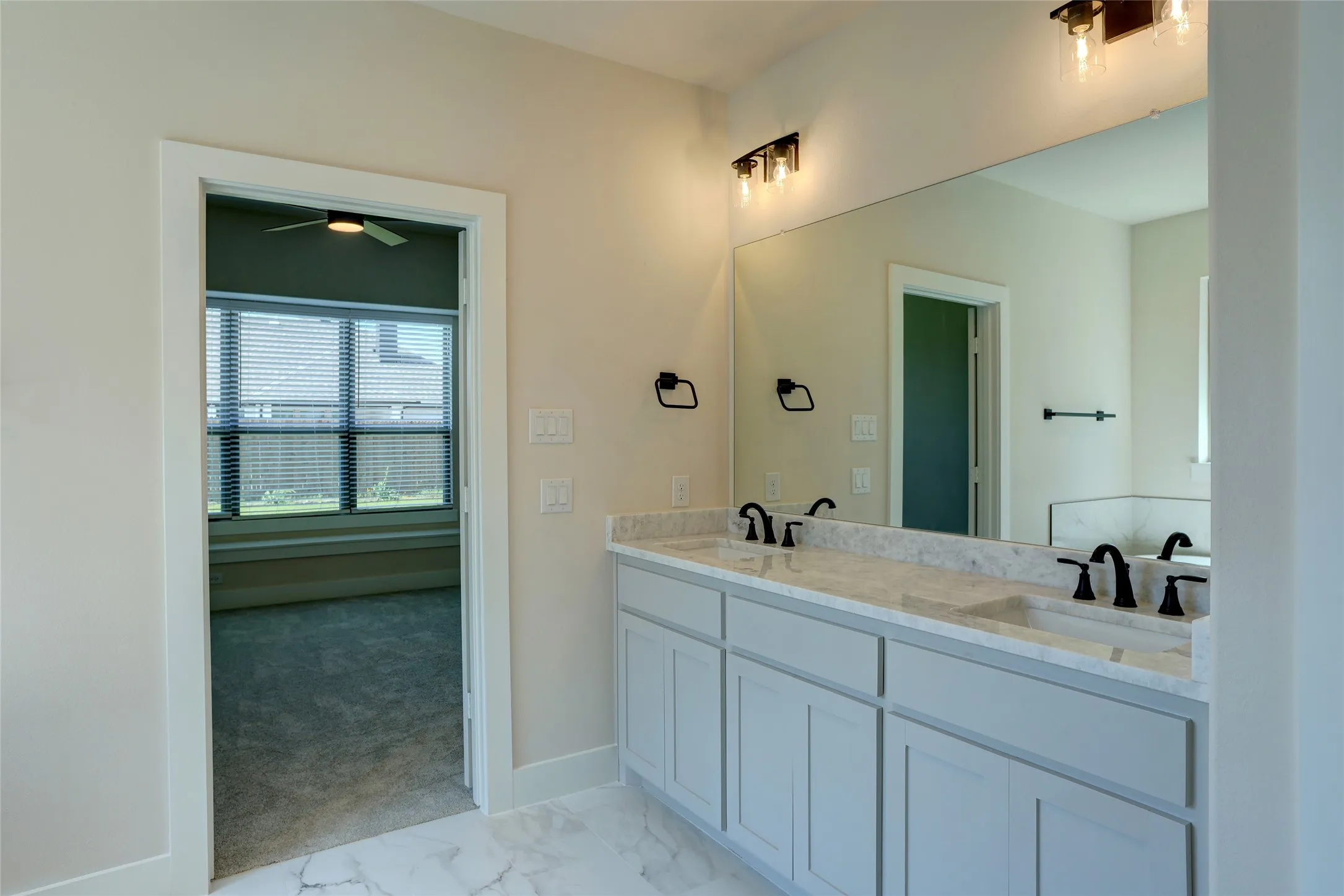 Double vanity with stone countertop, undermount sinks, and matte black fixtures