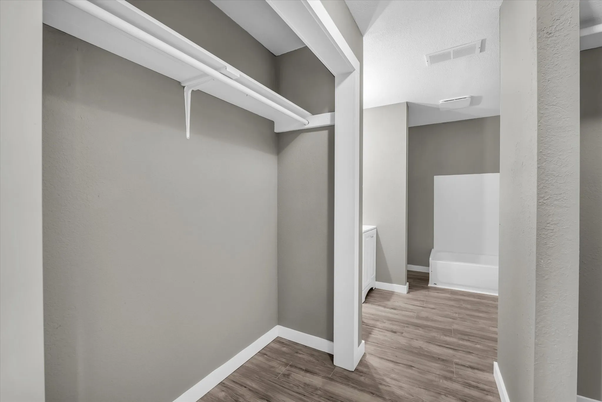 Entrance to the primary bathroom with closet space on either side