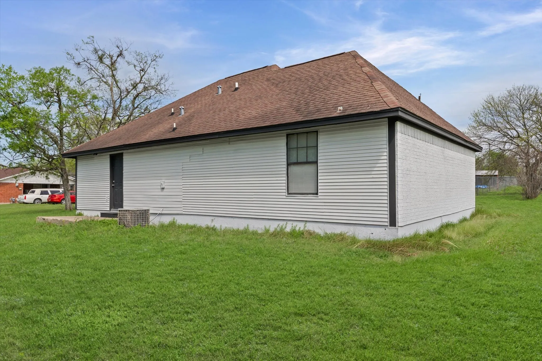View of home's exterior featuring a yard and roof with shingles
