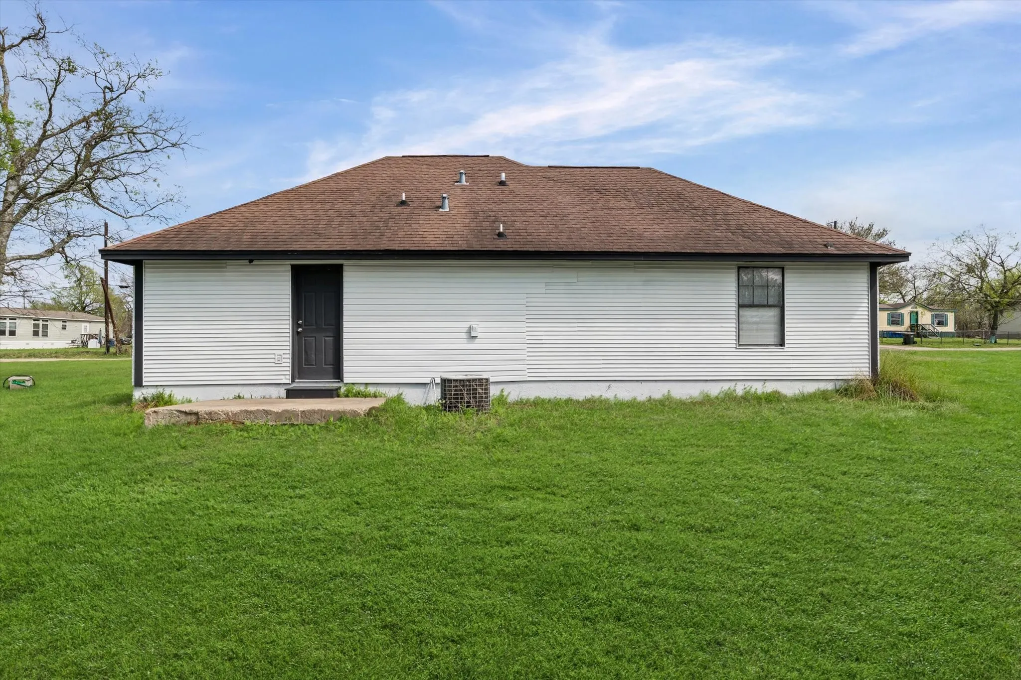 Back of house with a yard and a shingled roof