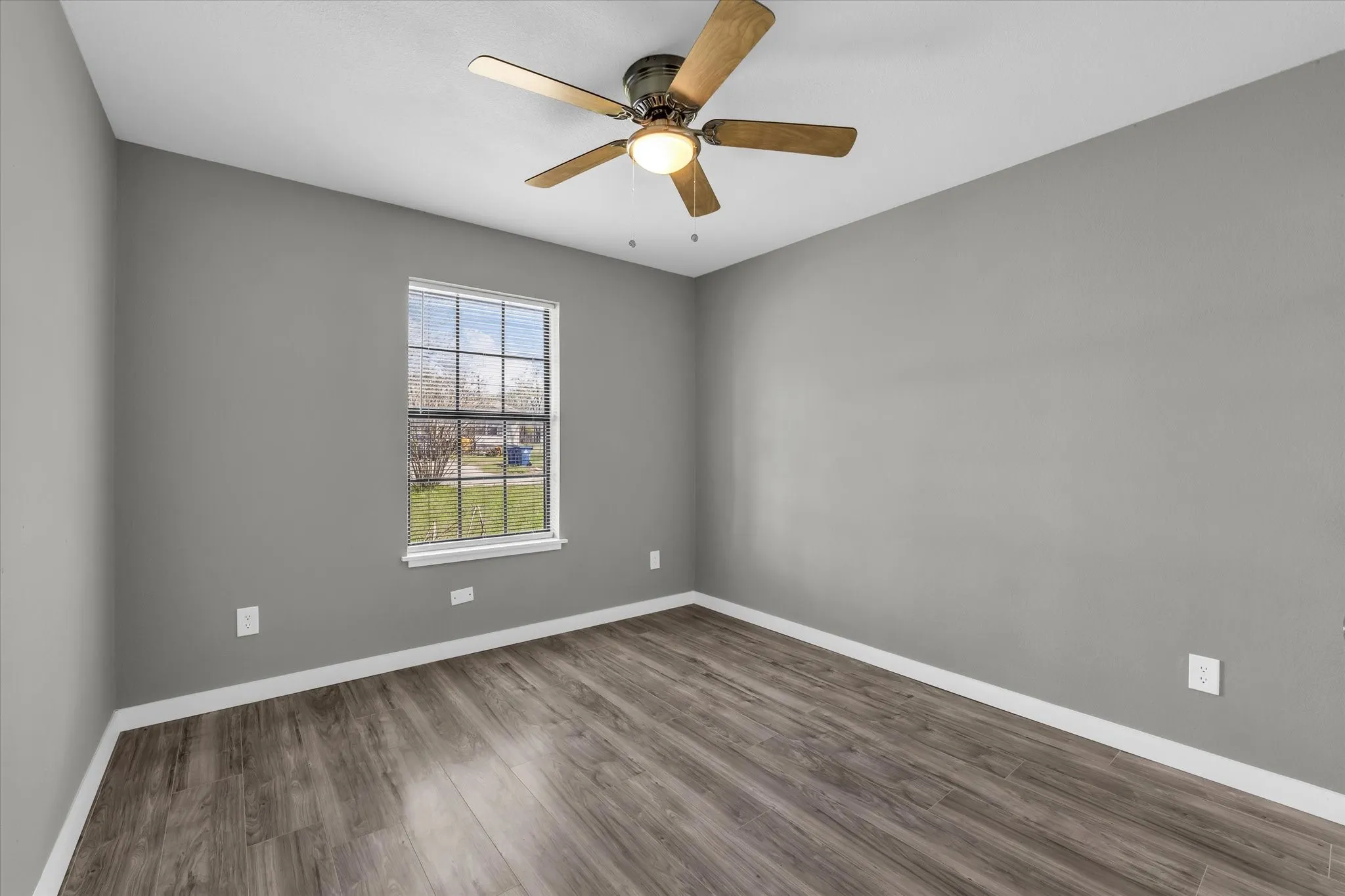 Spare bedroom featuring dark wood-style flooring and ceiling fan