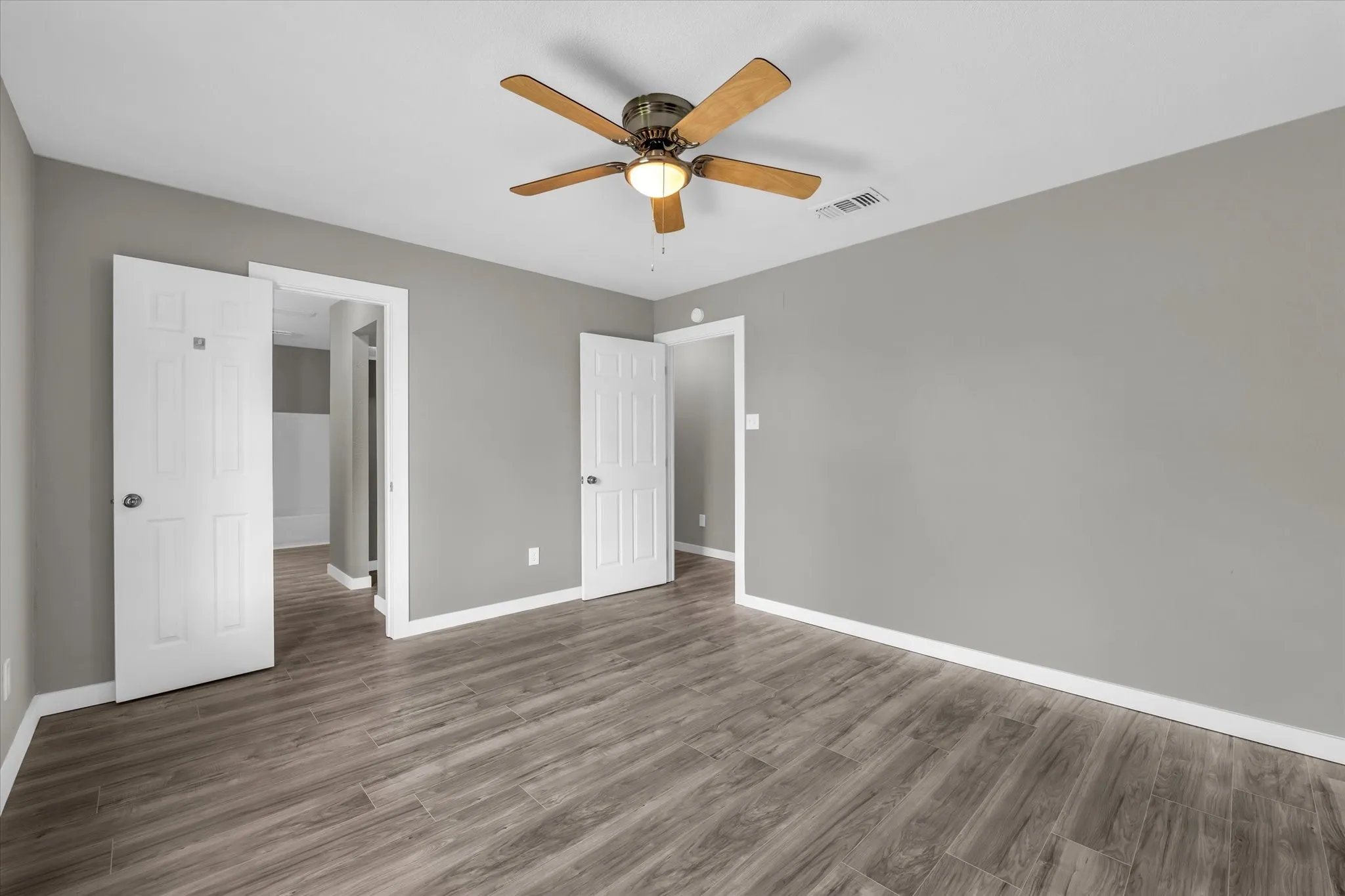 Unfurnished bedroom with dark wood-style flooring and a ceiling fan