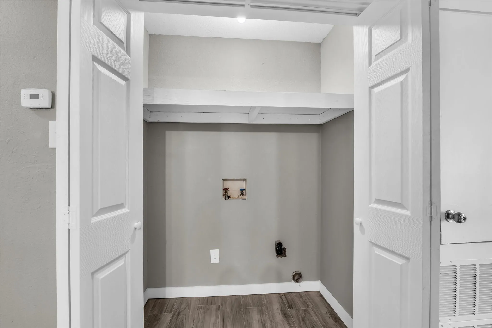 Laundry area with wood finished floors and washer hookup
