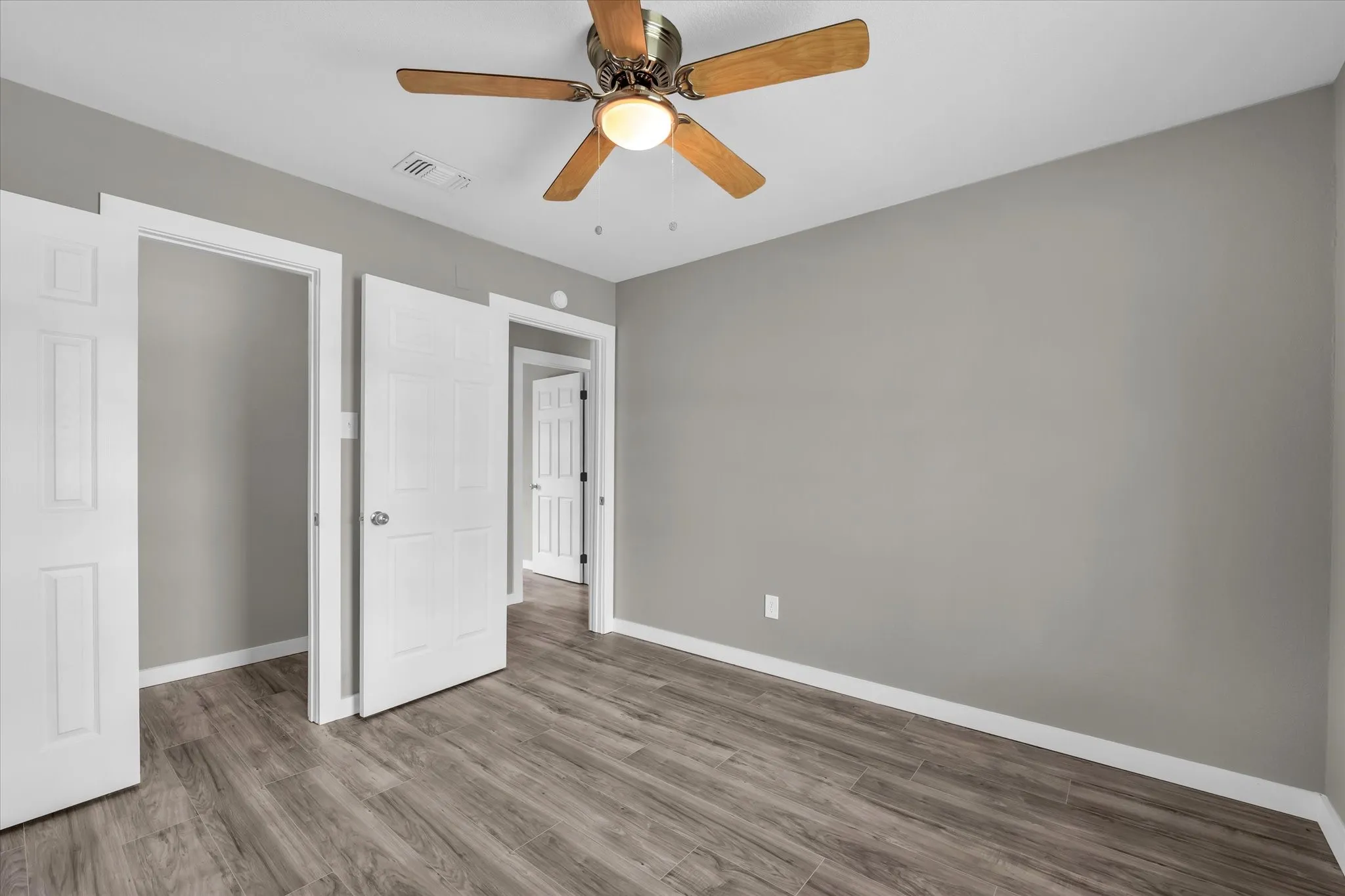 Unfurnished bedroom featuring wood finished floors and ceiling fan