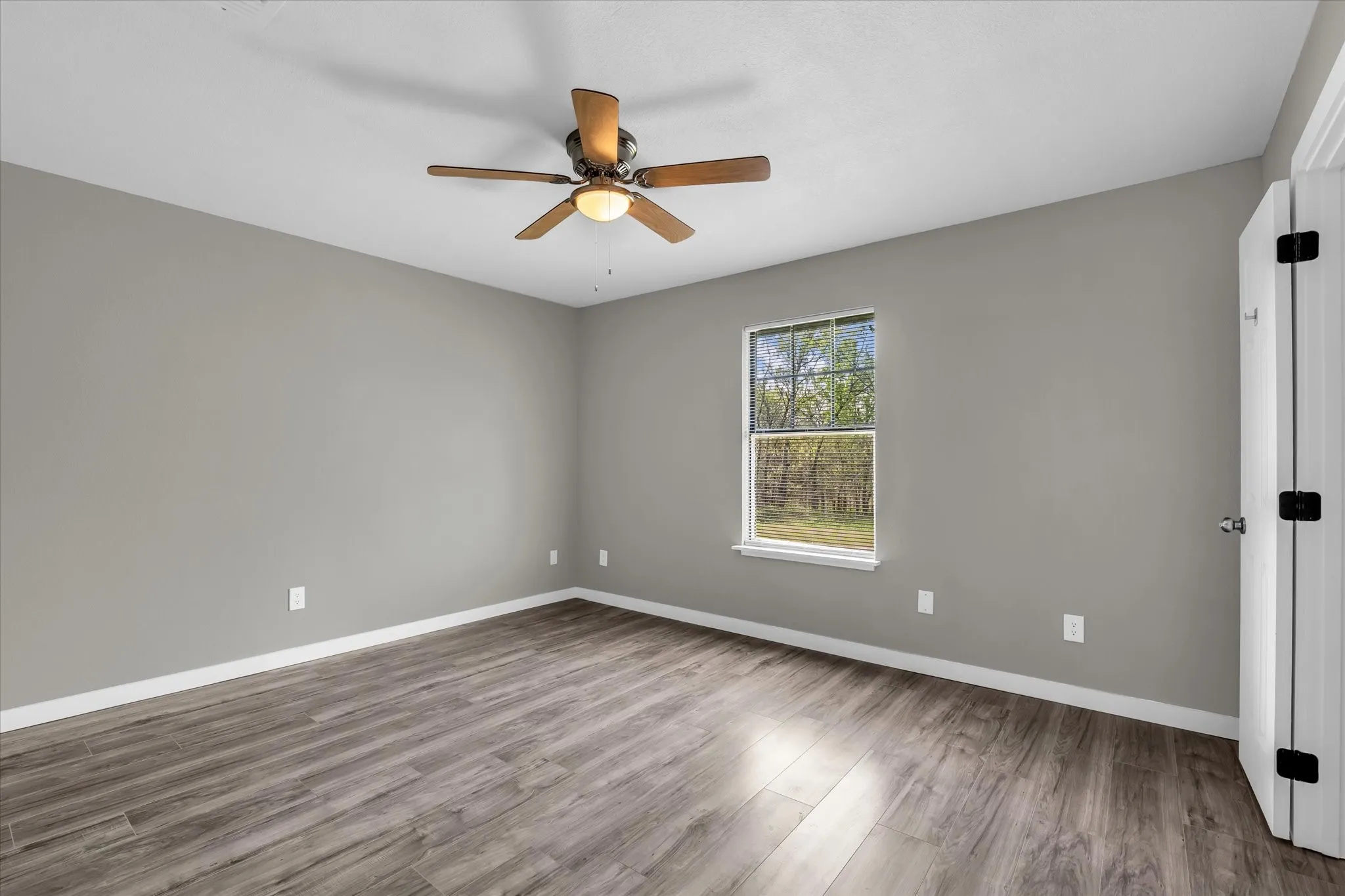 Unfurnished room featuring dark wood finished floors and a ceiling fan