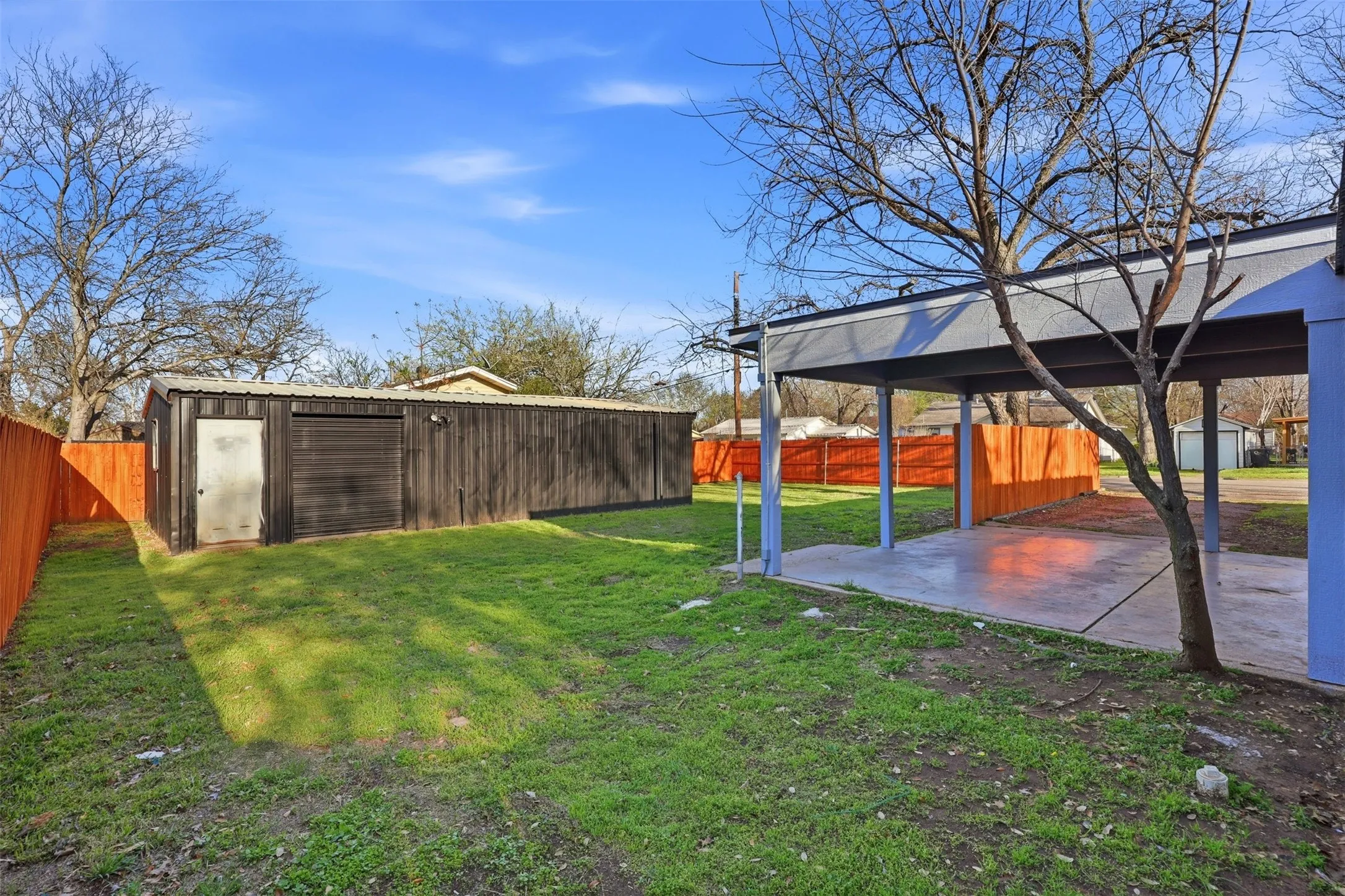View of backyard featuring a covered carport/ patio with large work