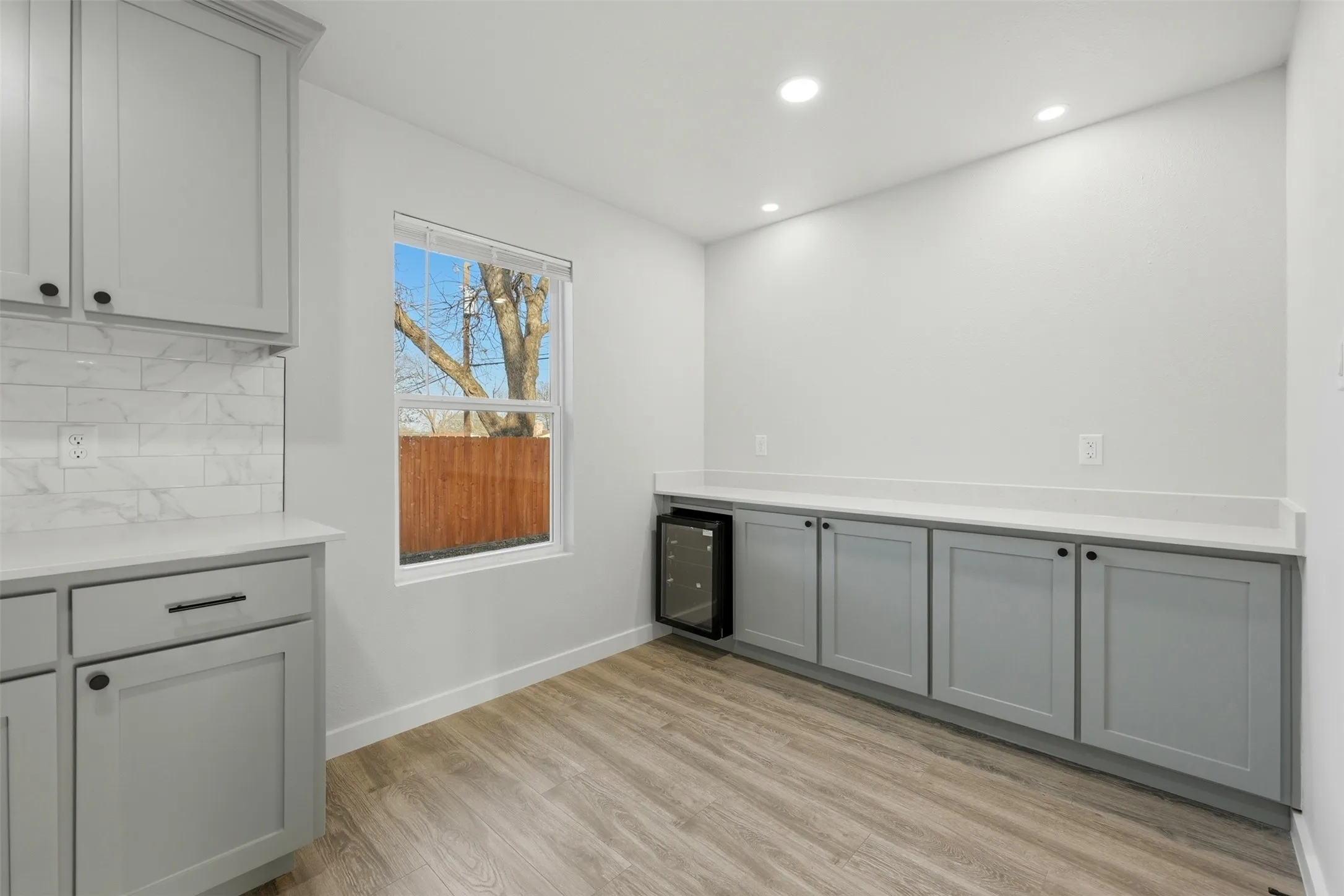 Kitchen area with built in wine fridge and extra cabinet space.