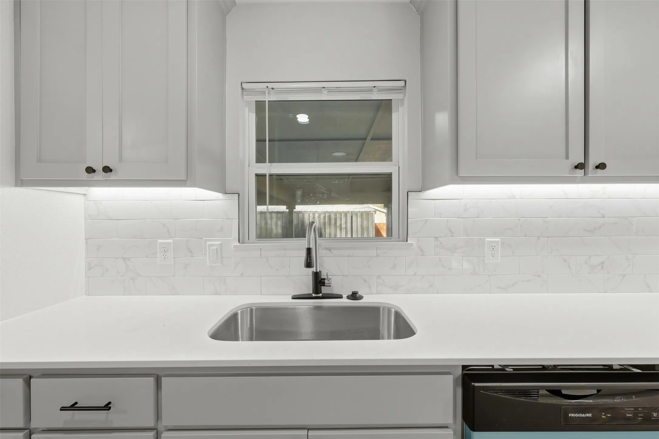 farn house sink in kitchen over looking backyard.