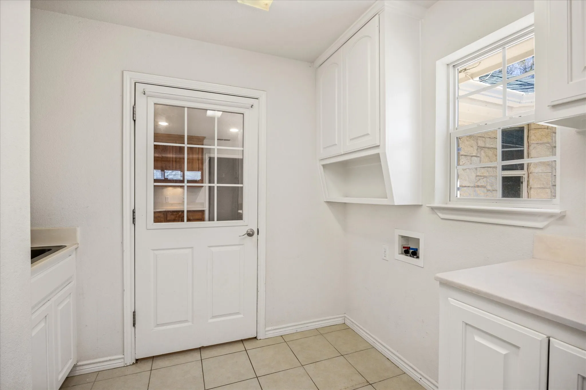 This laundry room has a storage closet, extra cabinets and a sink.  It also has the alarm system in it, so you can easily turn off when you arrive home.