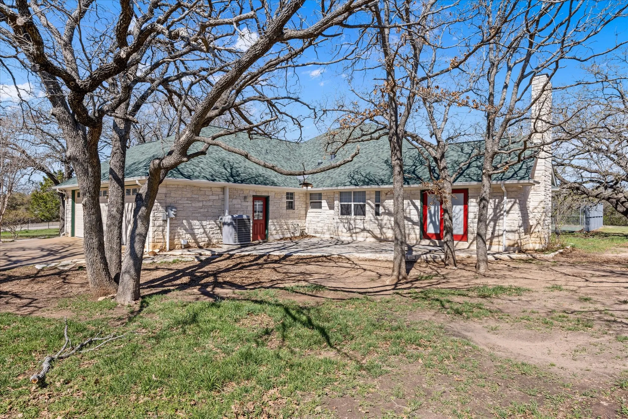 This is the back of the home showing a door into the garage and Also double doors out the Den to the rock patio.