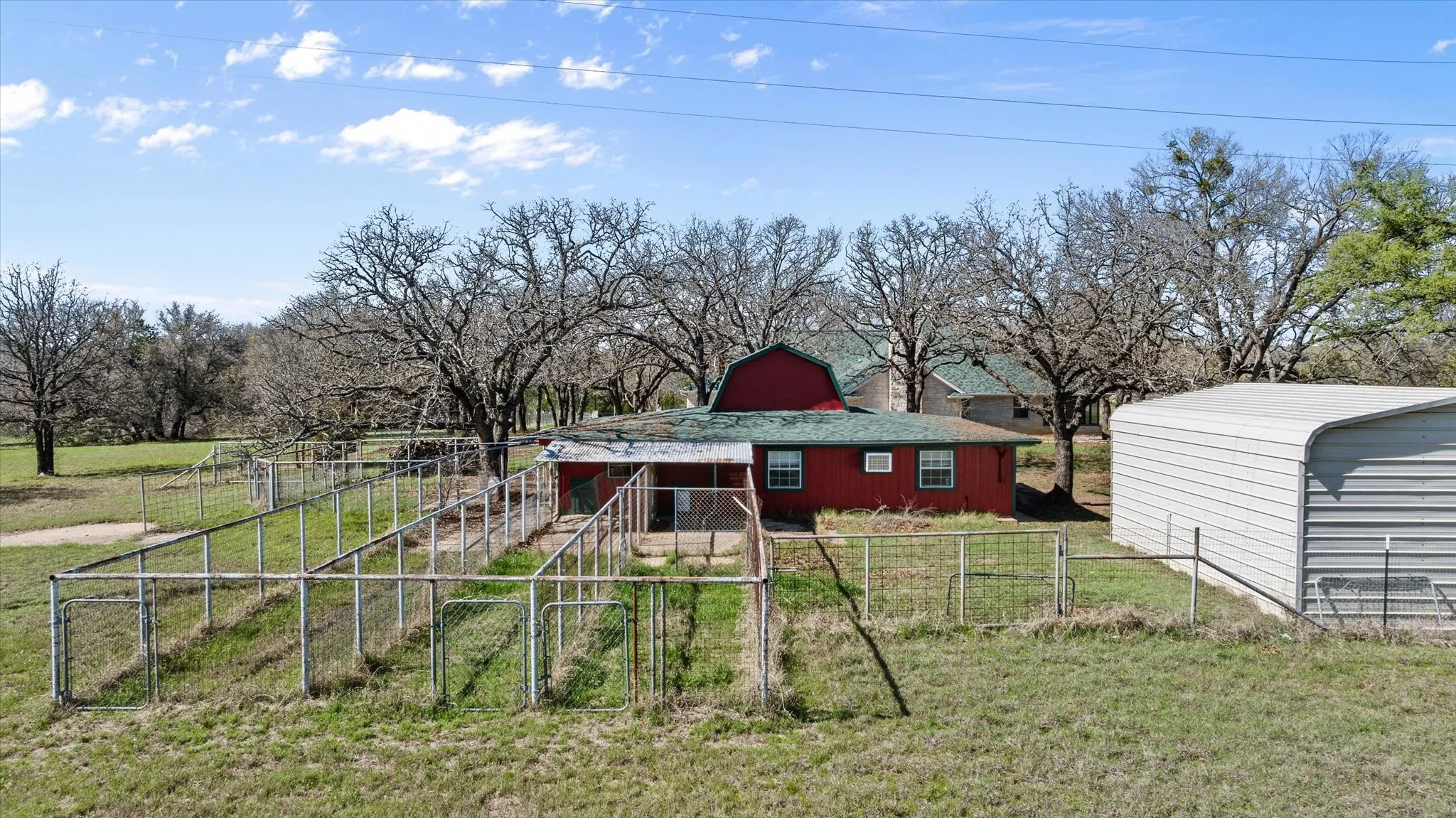 This is a great view of the dog runs and shows the outbuildings the dogs have door to get into.  The white building to the right would be a great workshop.