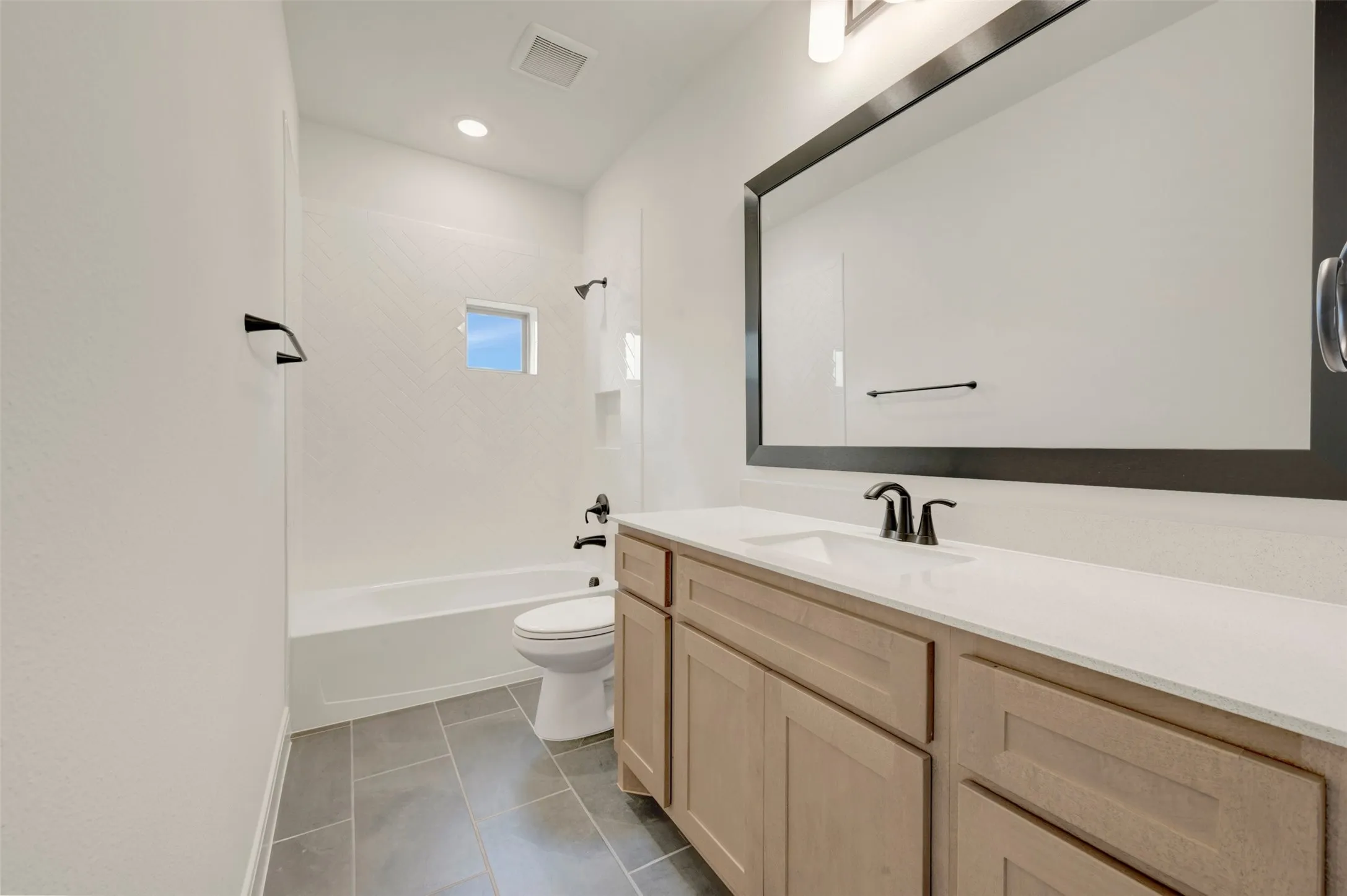 Bathroom featuring a light wood-finish vanity with a white countertop and integrated sink