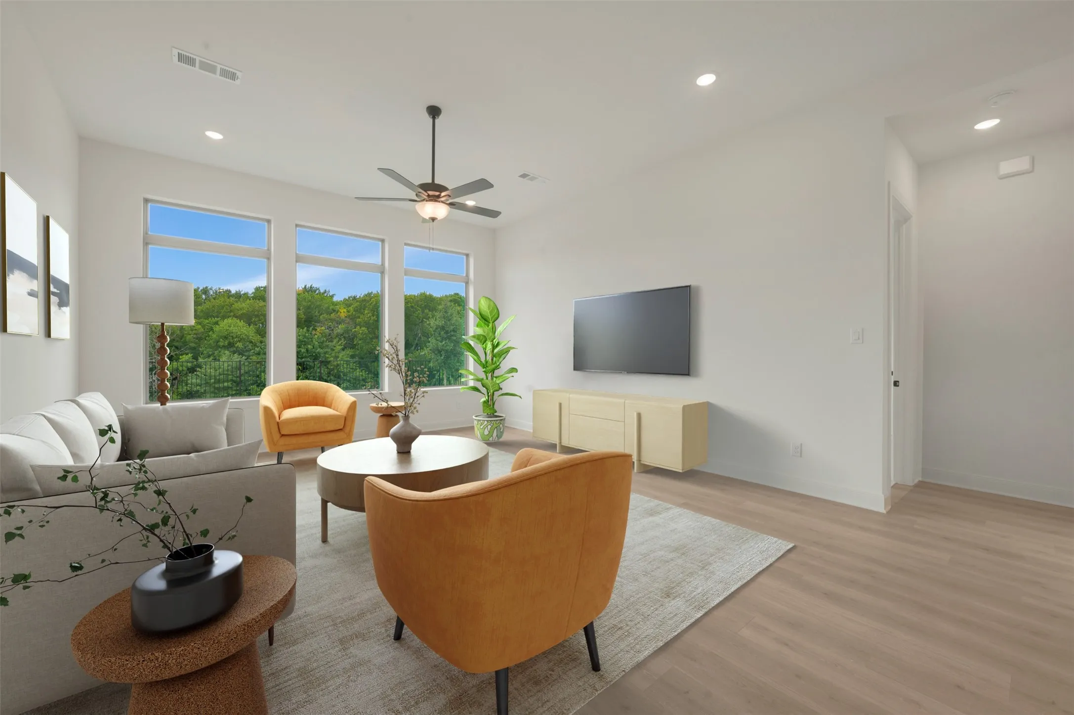 Spacious living area featuring large picture windows, wood-finish flooring, a ceiling fan, and recessed lighting