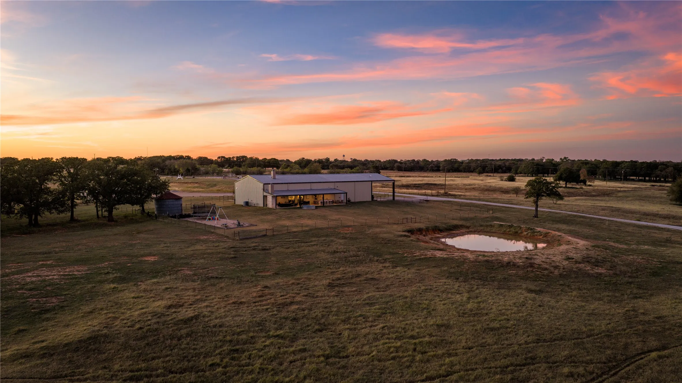 Sunset view across open pasture and ponds.