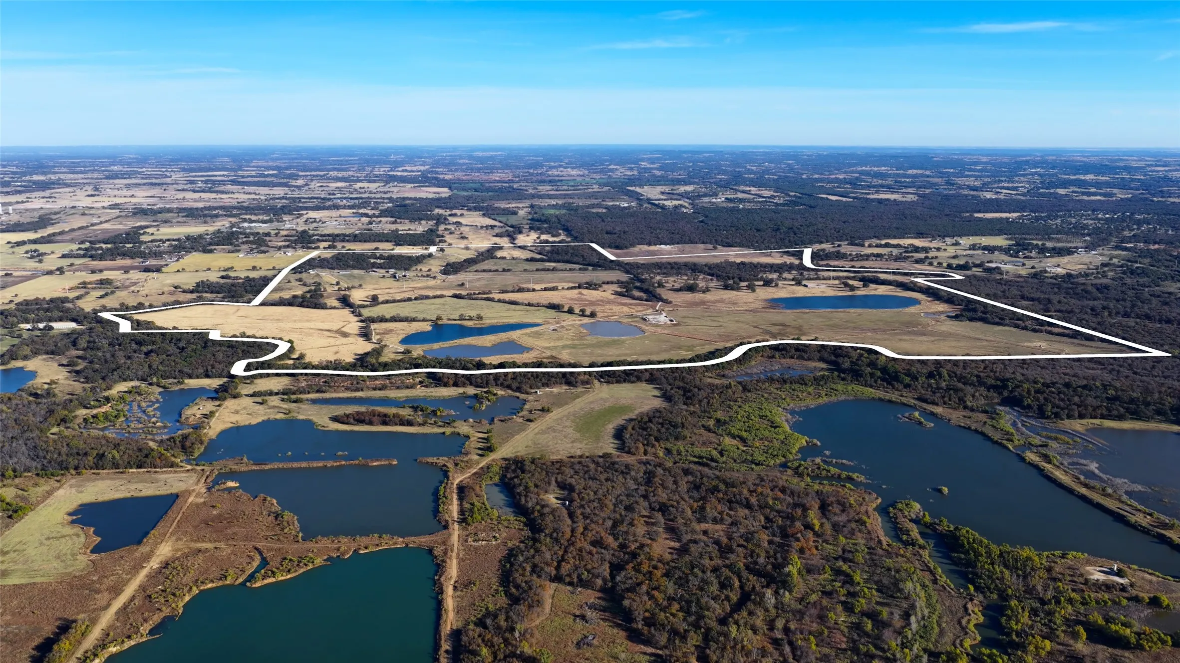 Wide aerial perspective highlighting ponds and surrounding countryside.