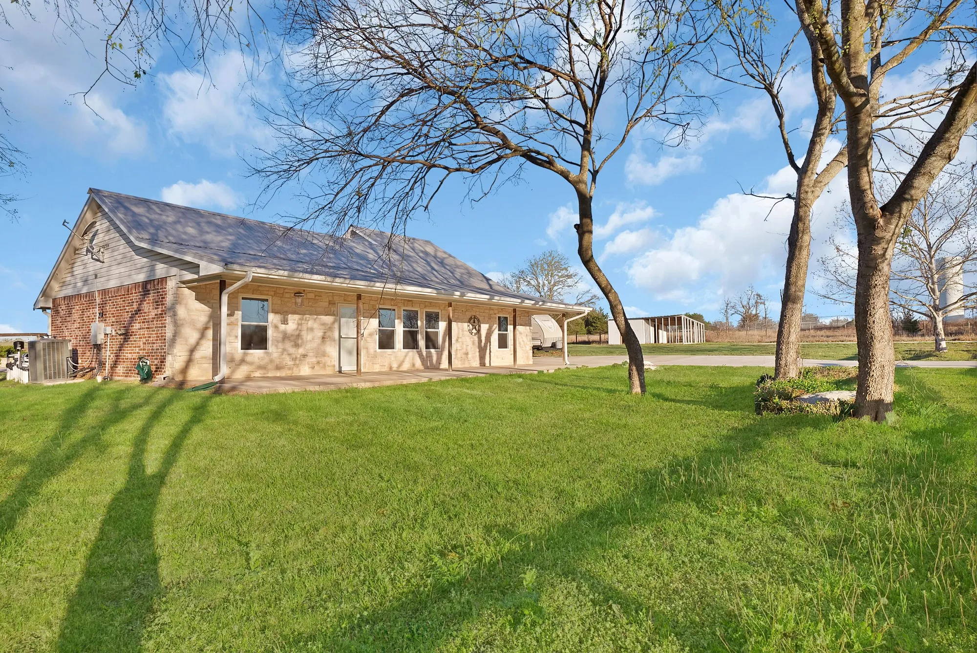 Back of property featuring brick siding and a lawn