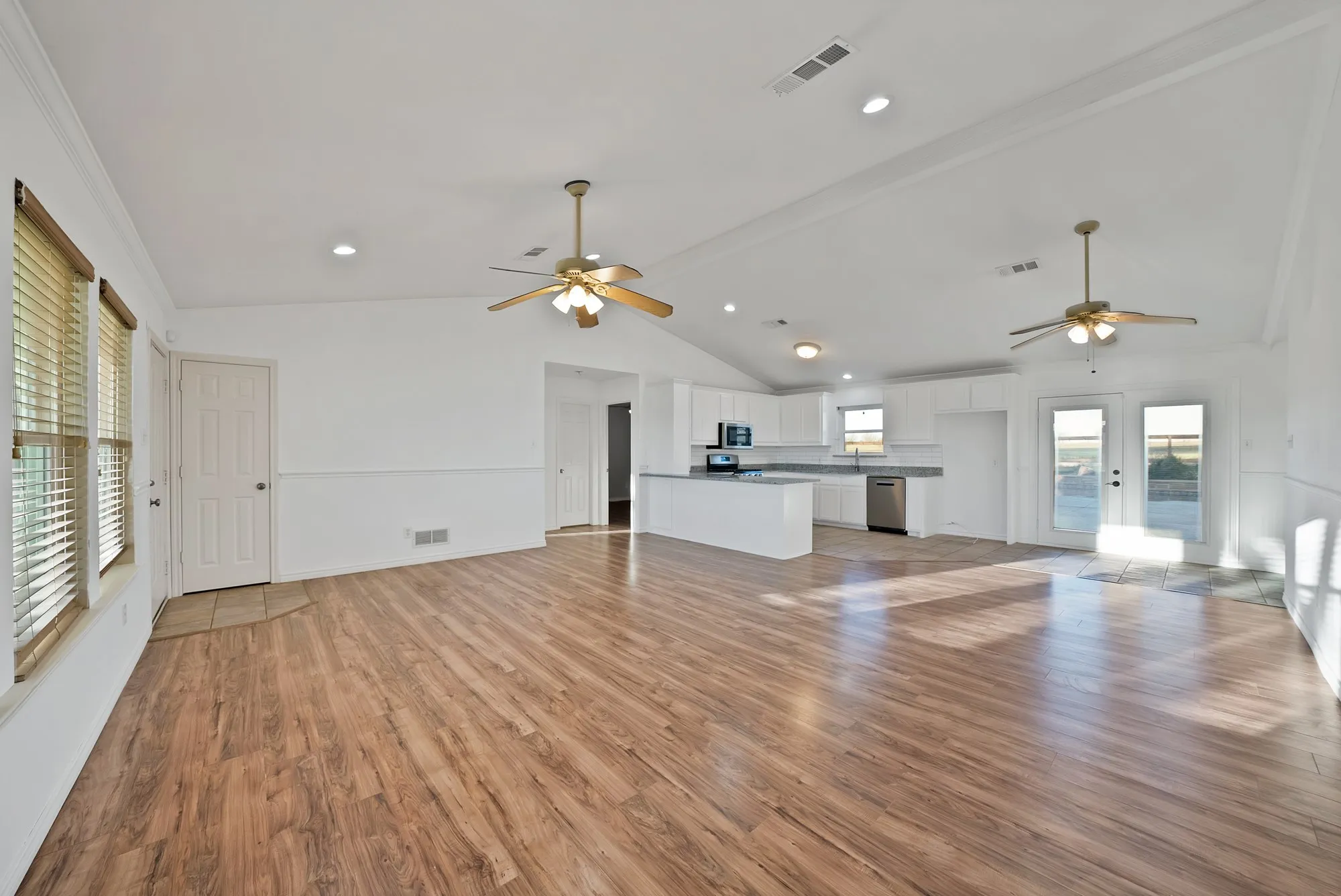 Unfurnished living room featuring ceiling fan, light wood-style flooring, beamed ceiling, recessed lighting, and crown molding