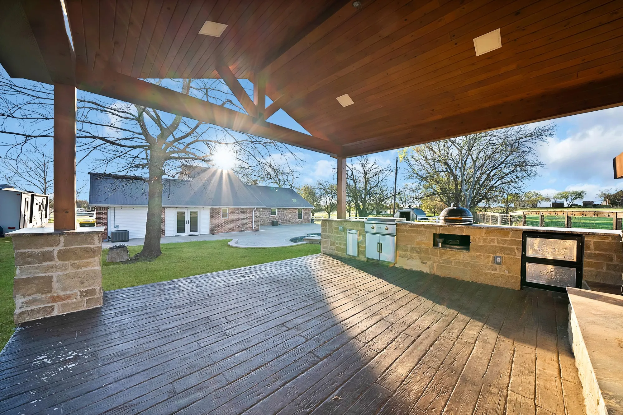 Deck with exterior kitchen, a lawn, a patio area, and french doors