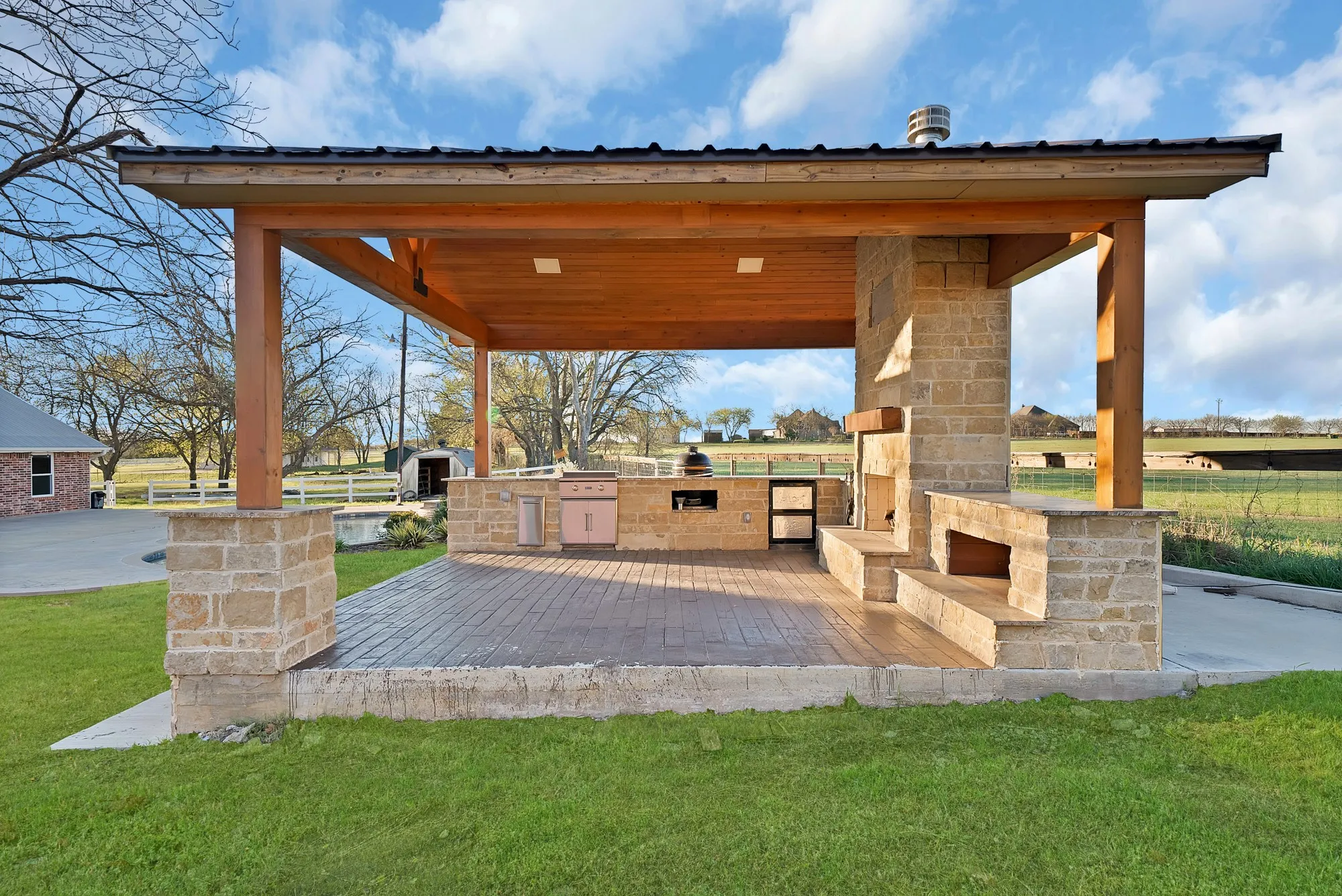 View of patio / terrace featuring area for grilling and an outdoor stone fireplace