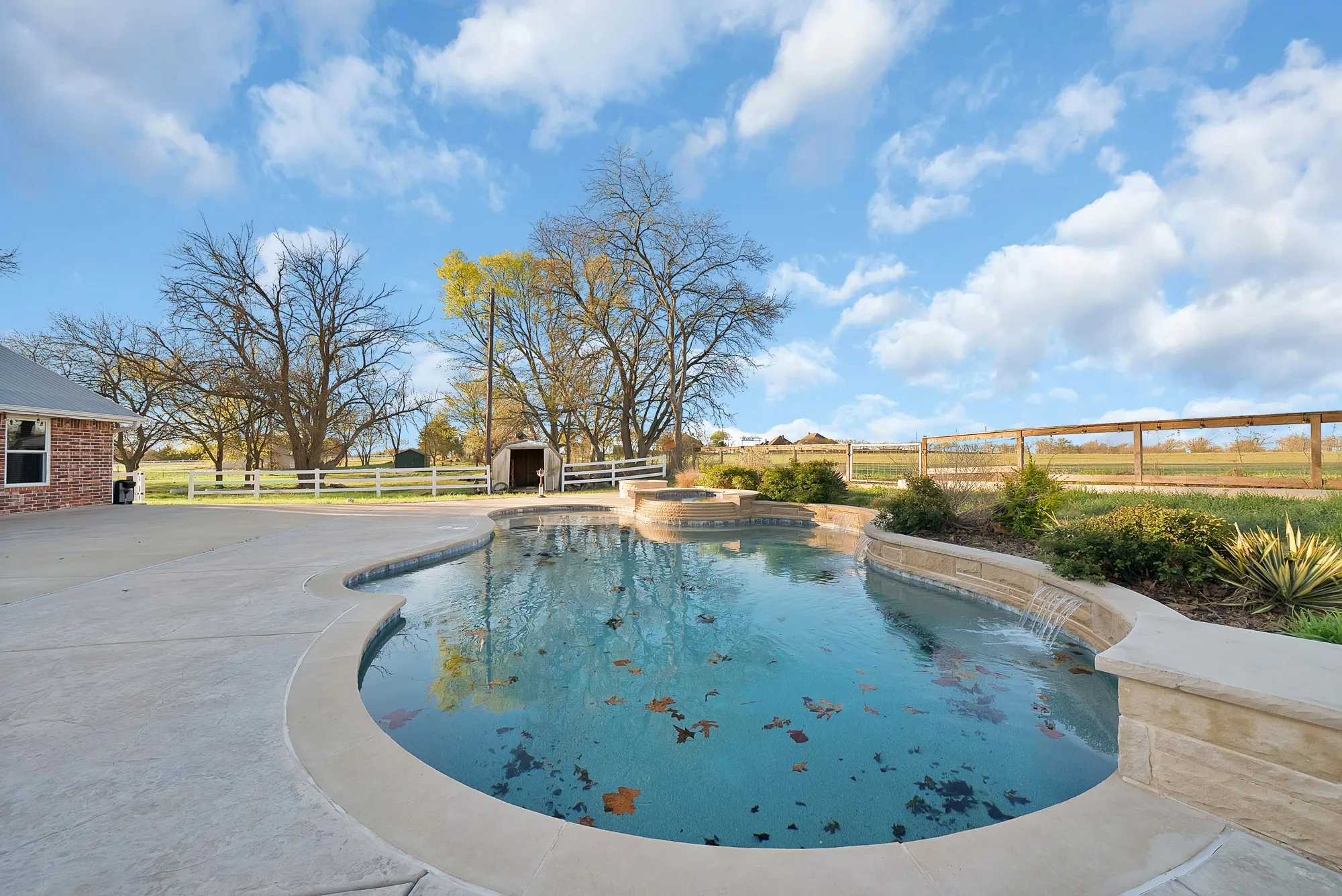 Integrated pool / hot tub featuring a fenced backyard and a patio area
