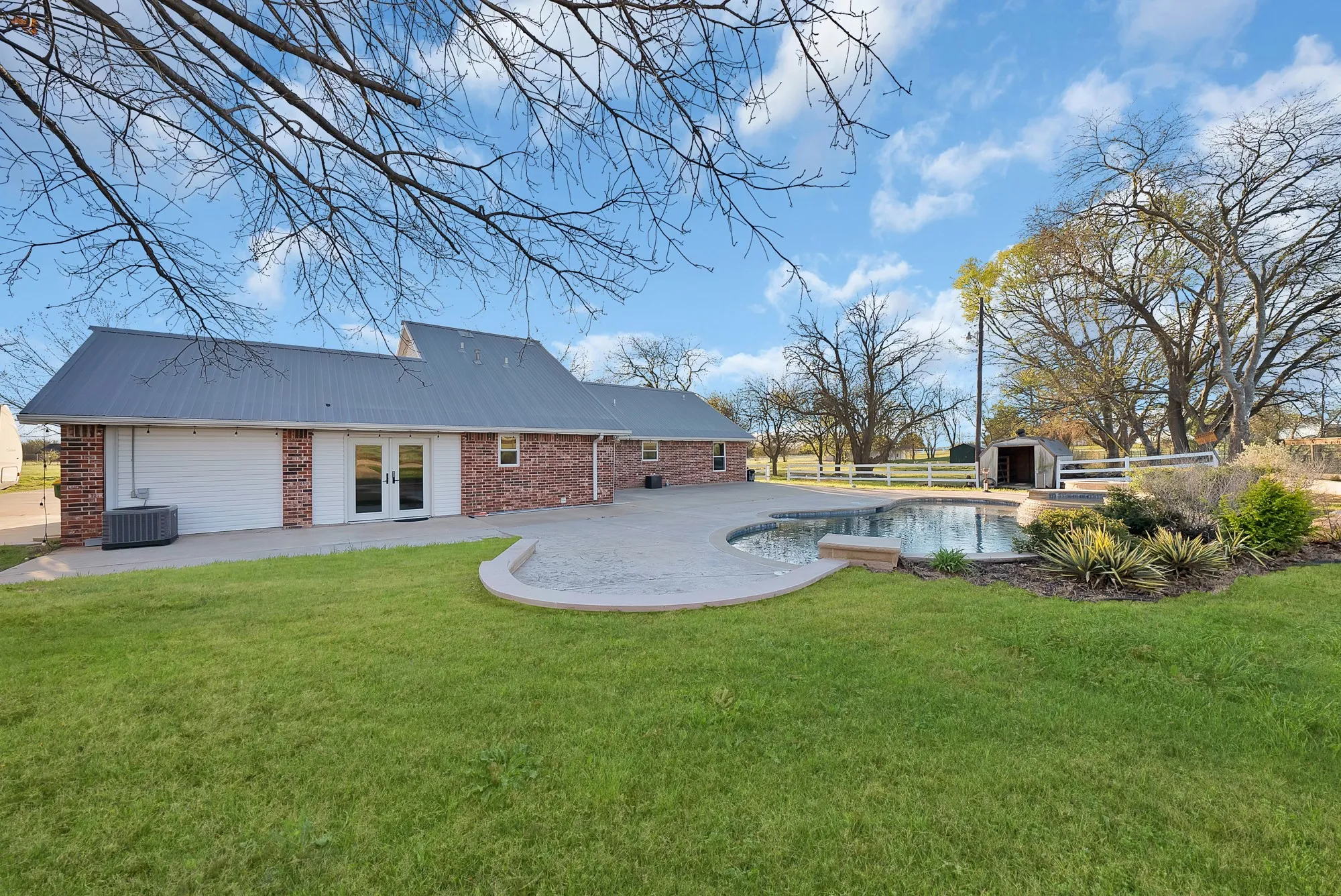 Rear view of property featuring a patio, an outdoor pool, a yard, and brick siding