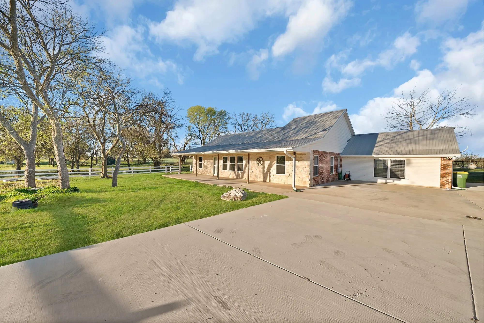 View of front of home with driveway, brick siding, and a front yard