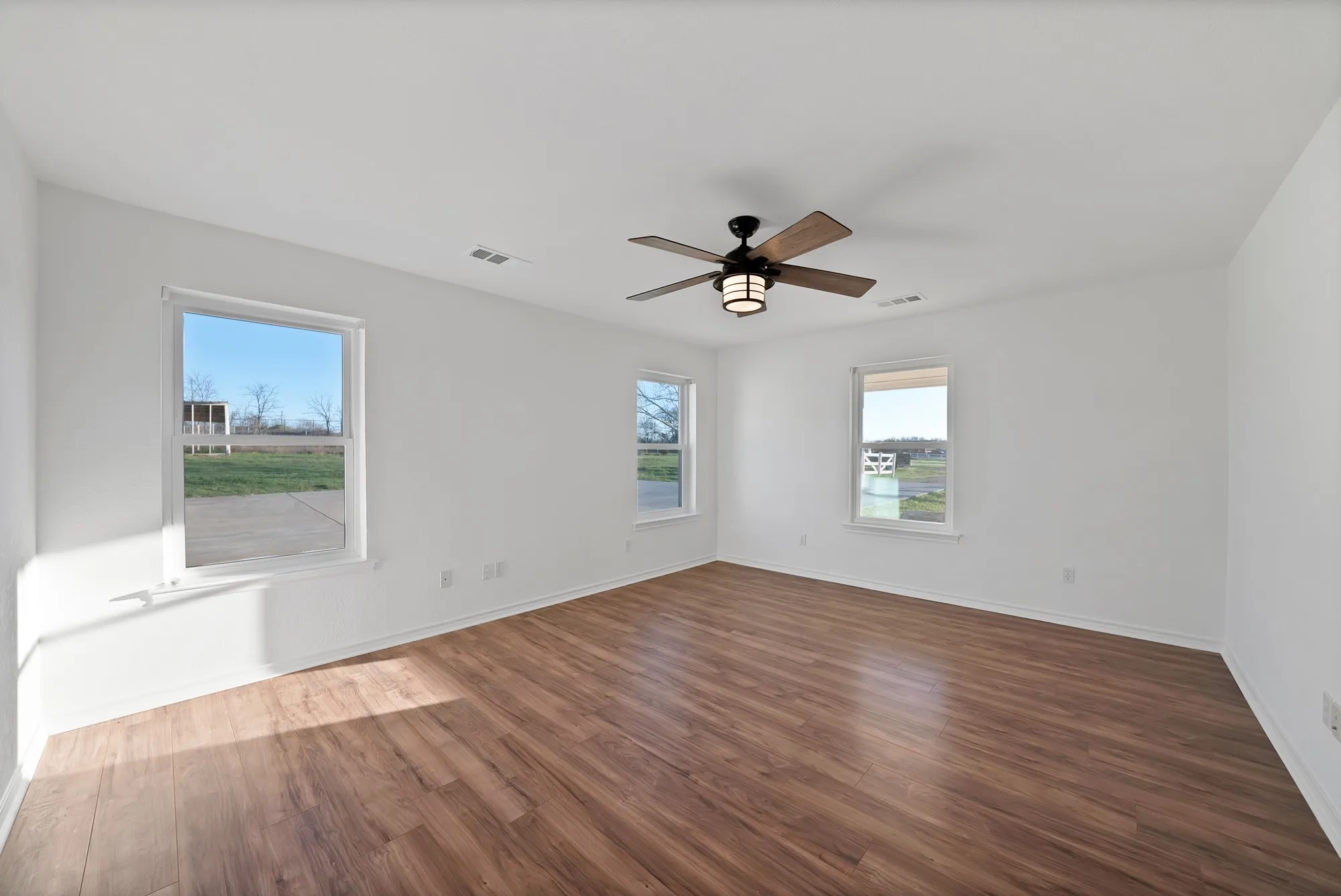 Spare room with dark wood finished floors and ceiling fan