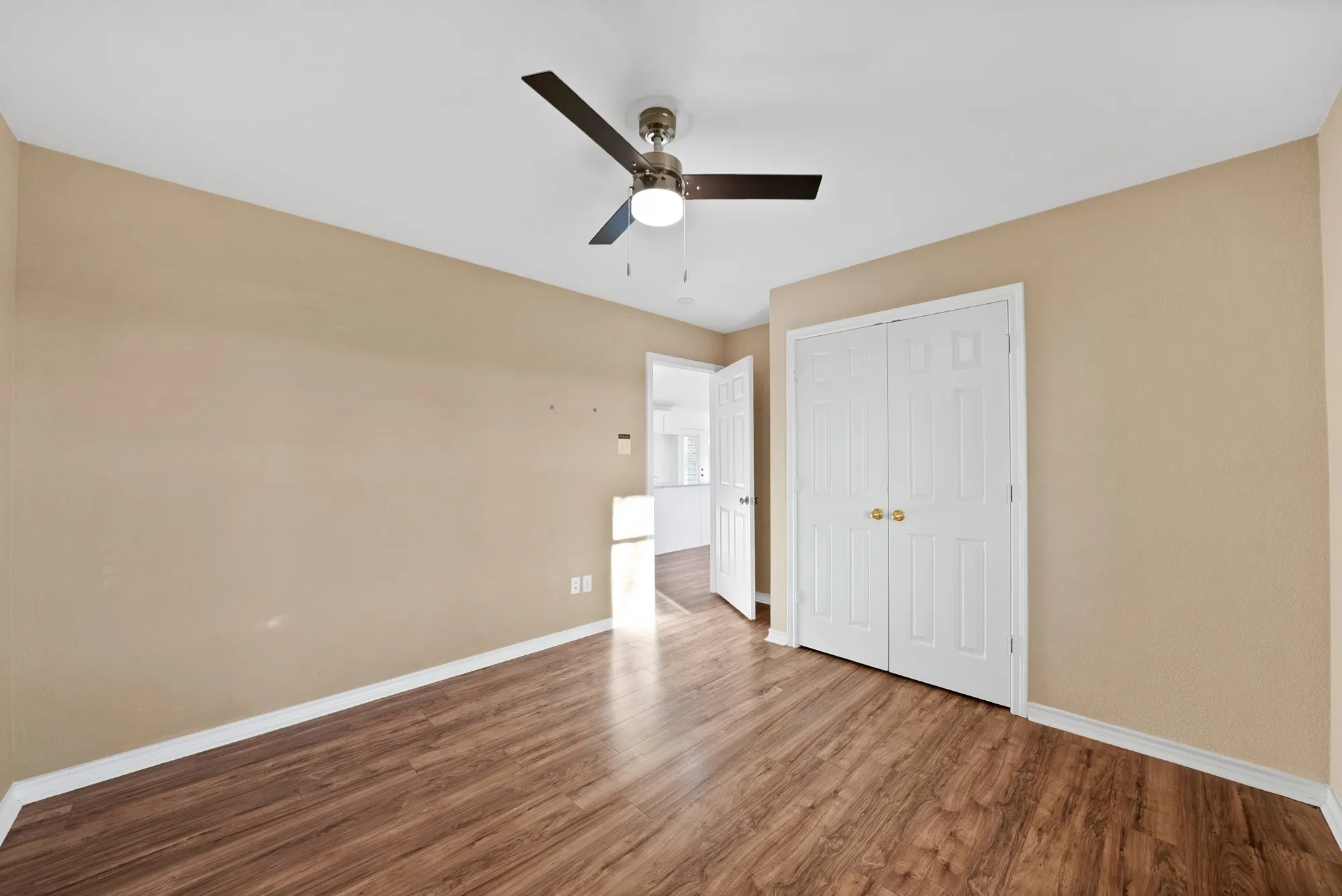 Unfurnished bedroom featuring wood finished floors, a ceiling fan, and a closet