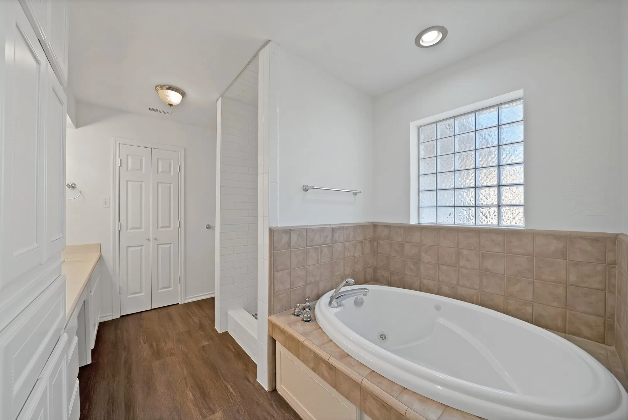 Full bathroom featuring vanity, a jetted tub, dark wood-type flooring, walk in shower, and recessed lighting