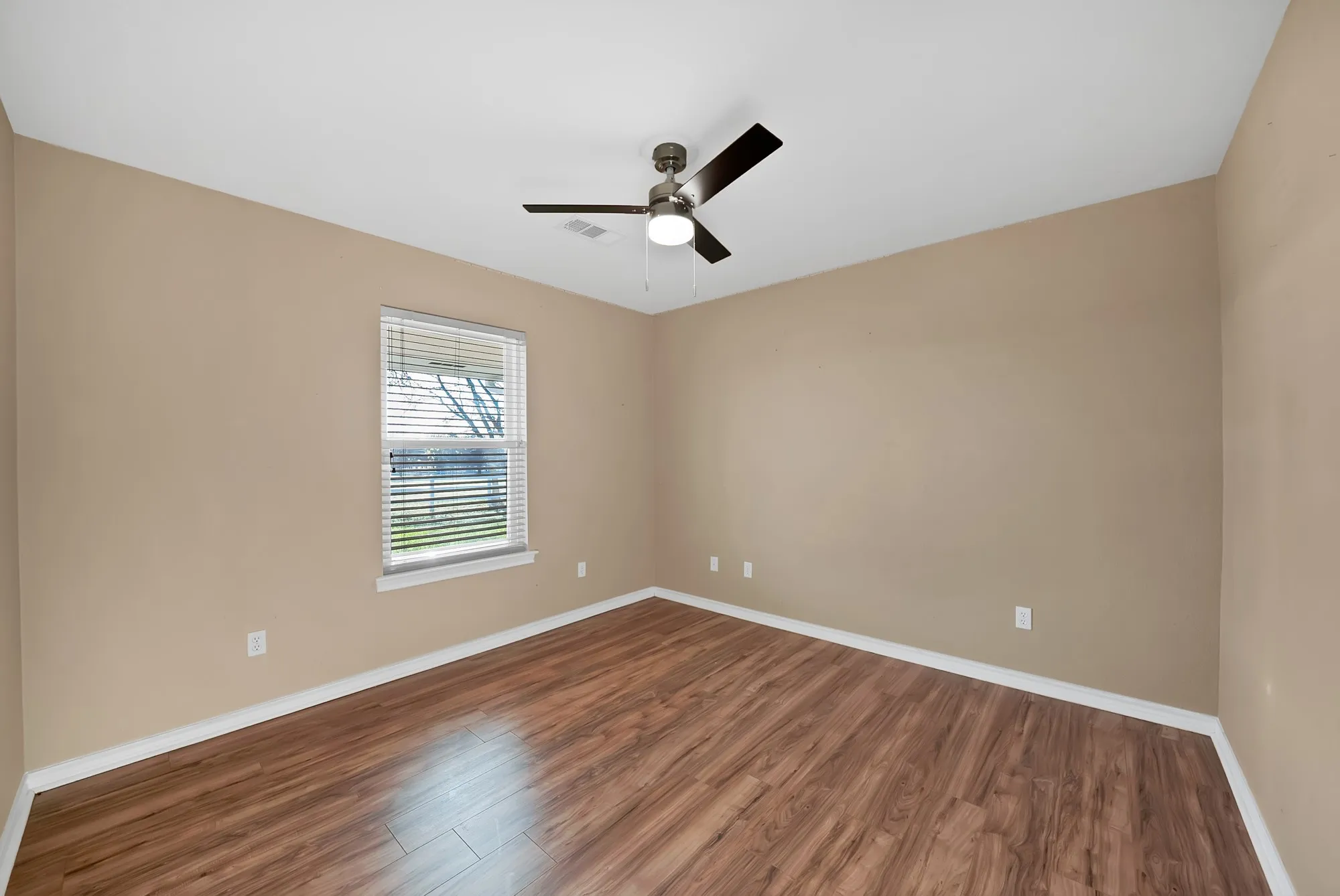 Empty room with dark wood-type flooring and a ceiling fan