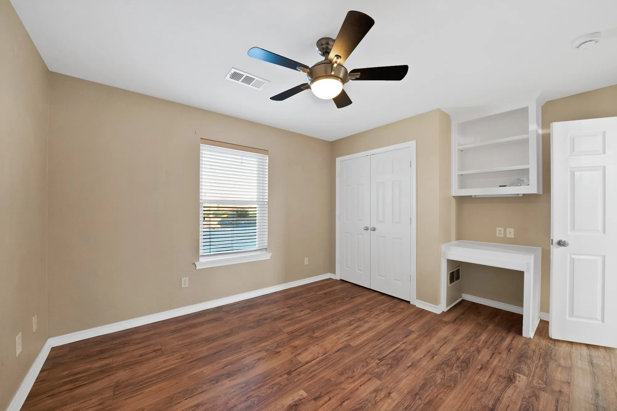 Unfurnished bedroom featuring dark wood-style flooring, a ceiling fan, and a closet