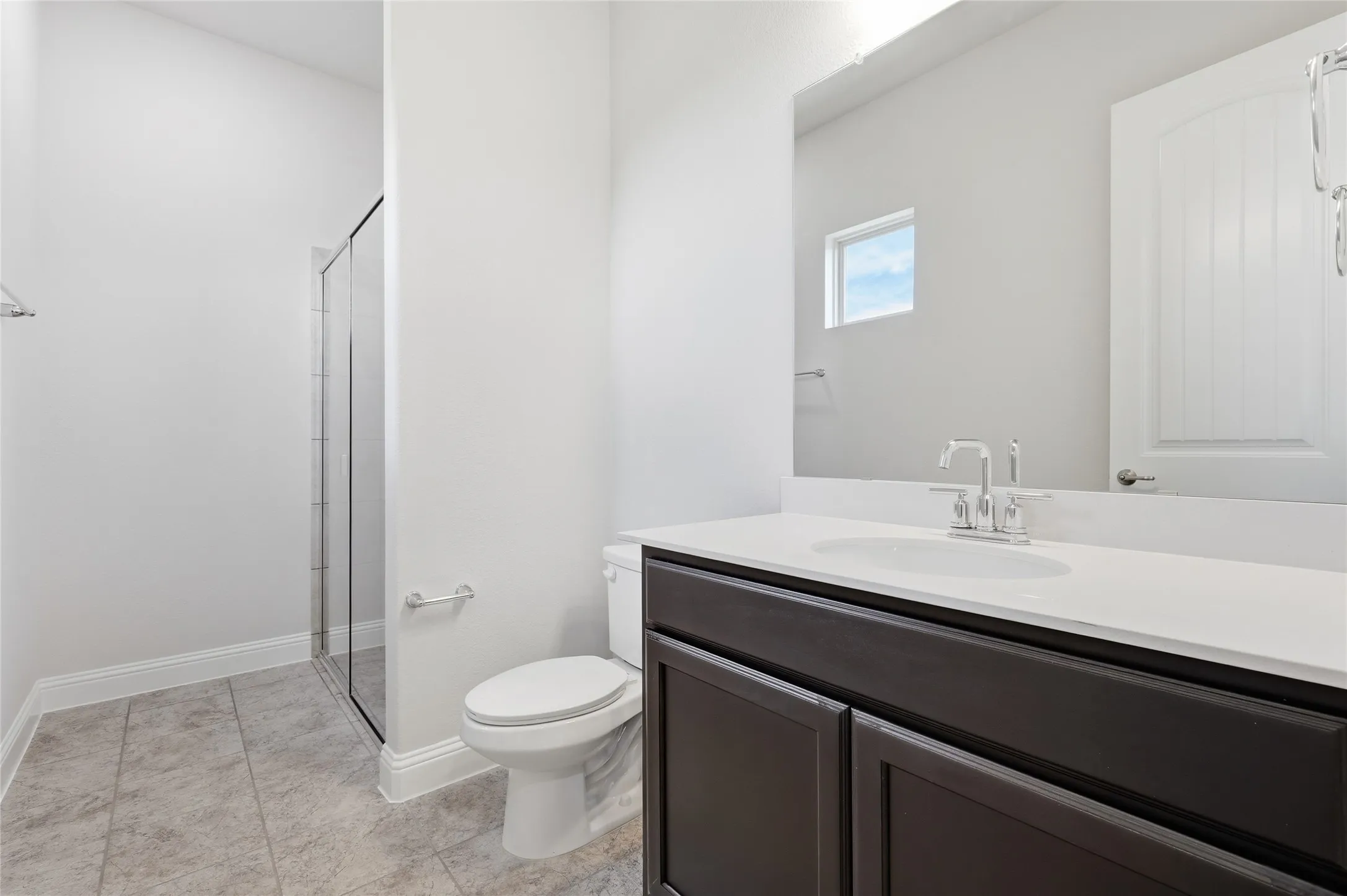 Bathroom with vanity, a shower stall, and light tile patterned floors